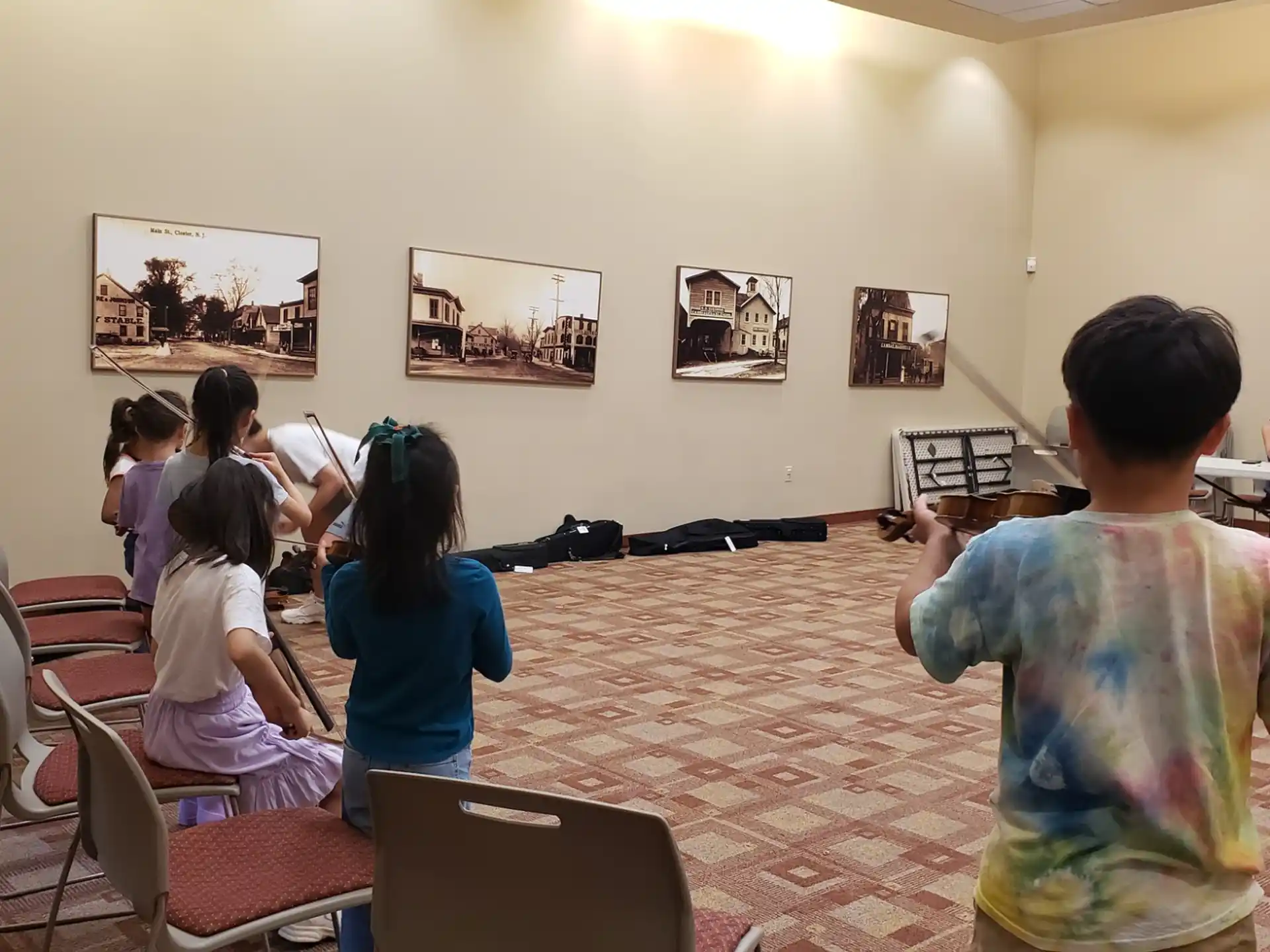 a group of people sitting in a room with art on the wall