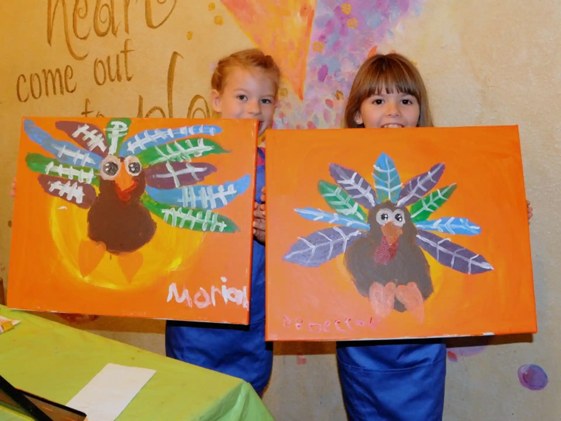 a couple of children holding paintings