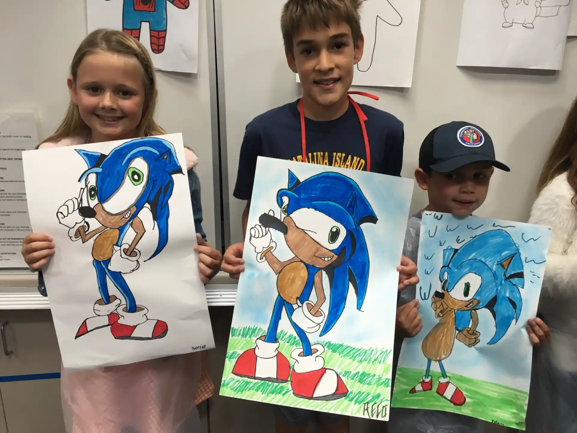 a group of children holding up drawings