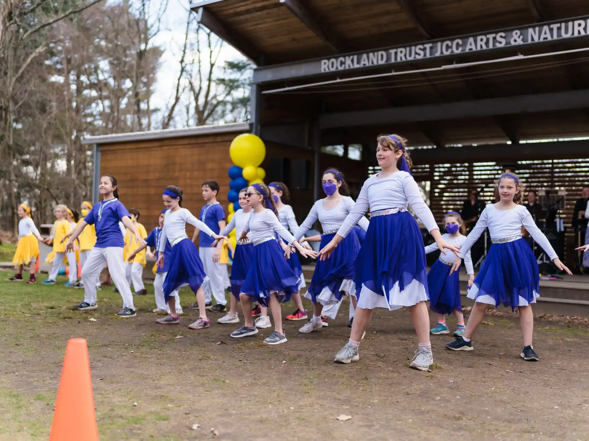a group of people in blue uniforms holding balloons