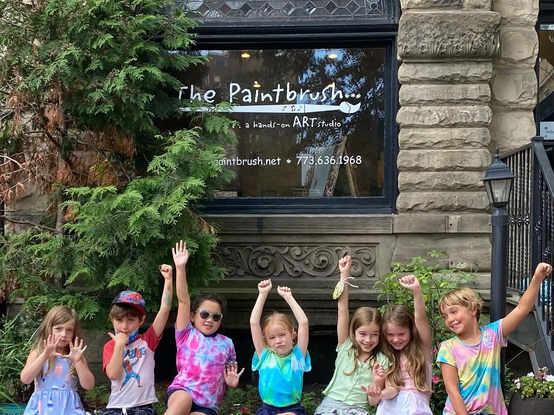 a group of children posing for a photo in front of a building