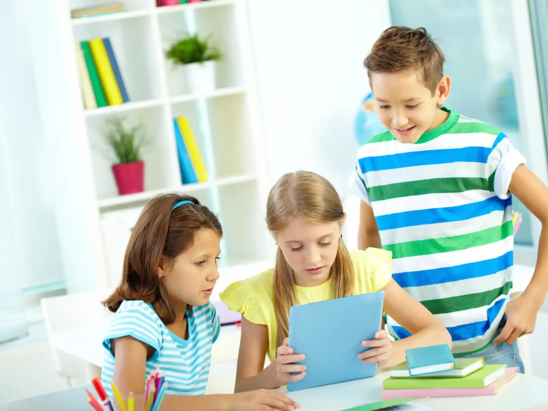 a group of children looking at a tablet