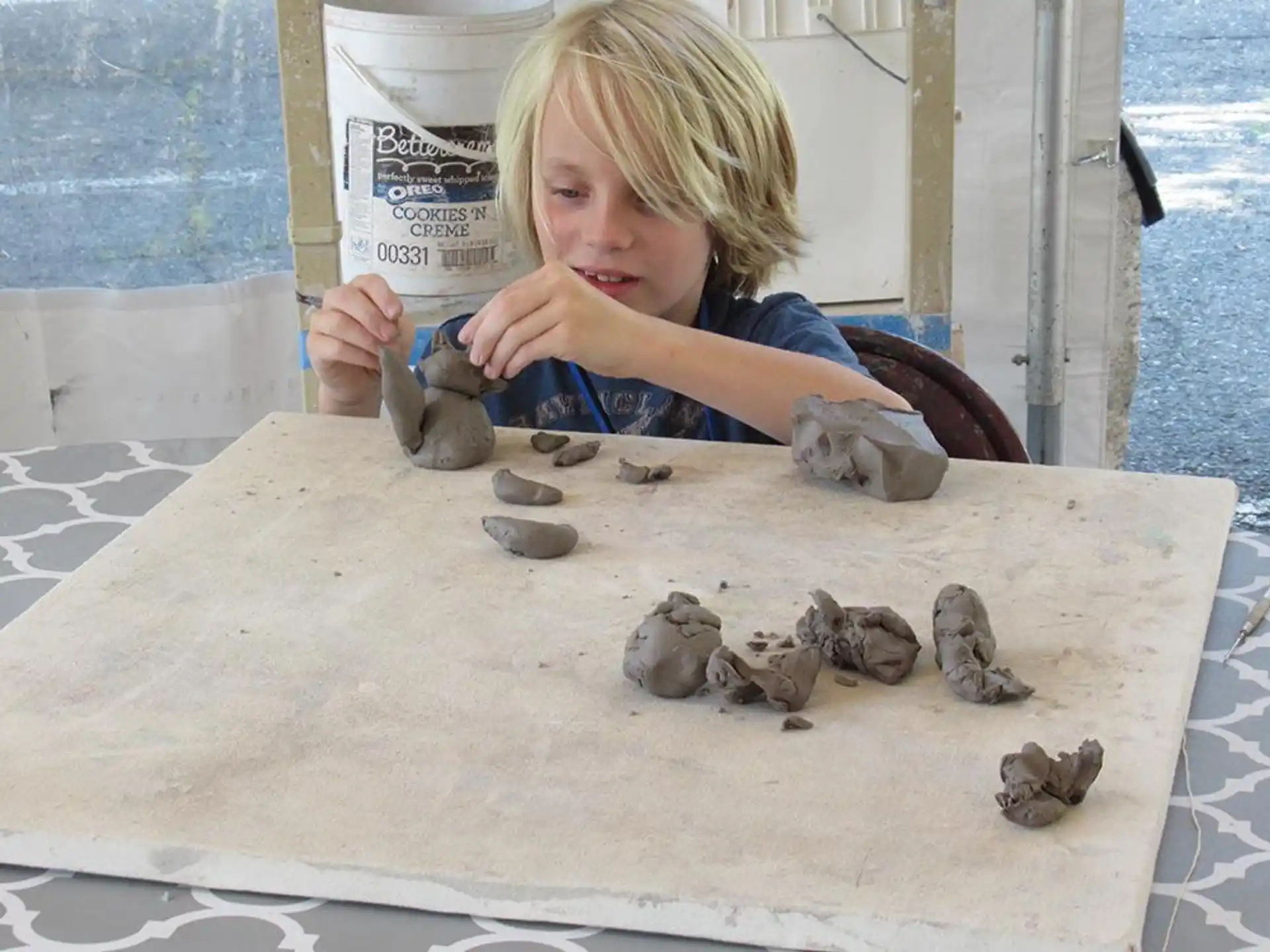 a girl sitting at a table with a pile of coins