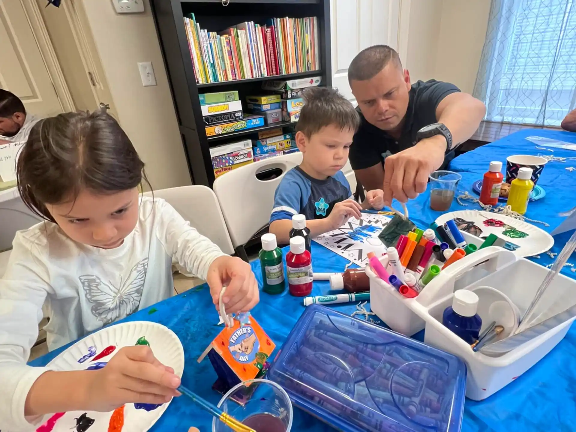 a group of people sitting around a table with toys