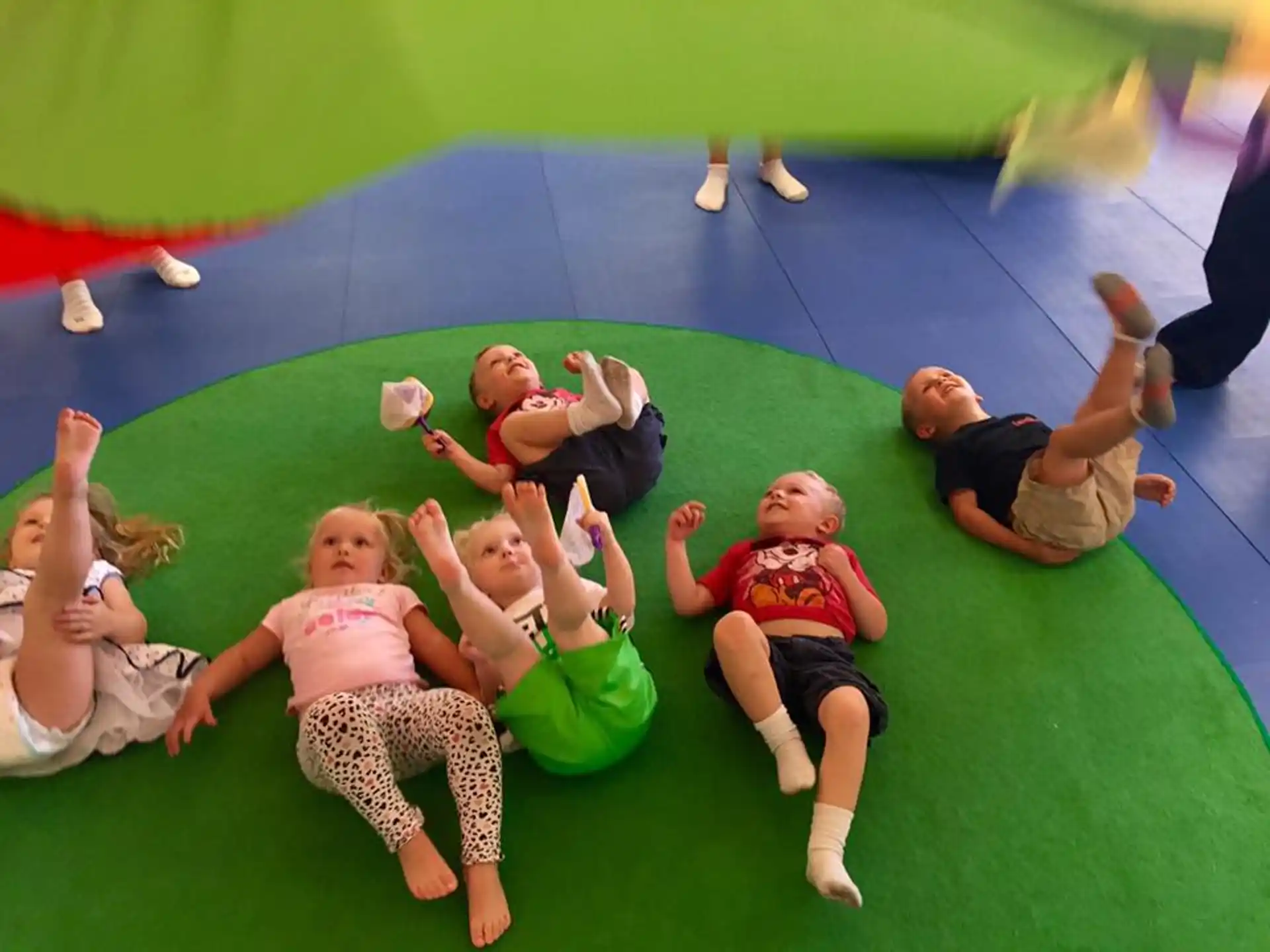 a group of children on a green mat