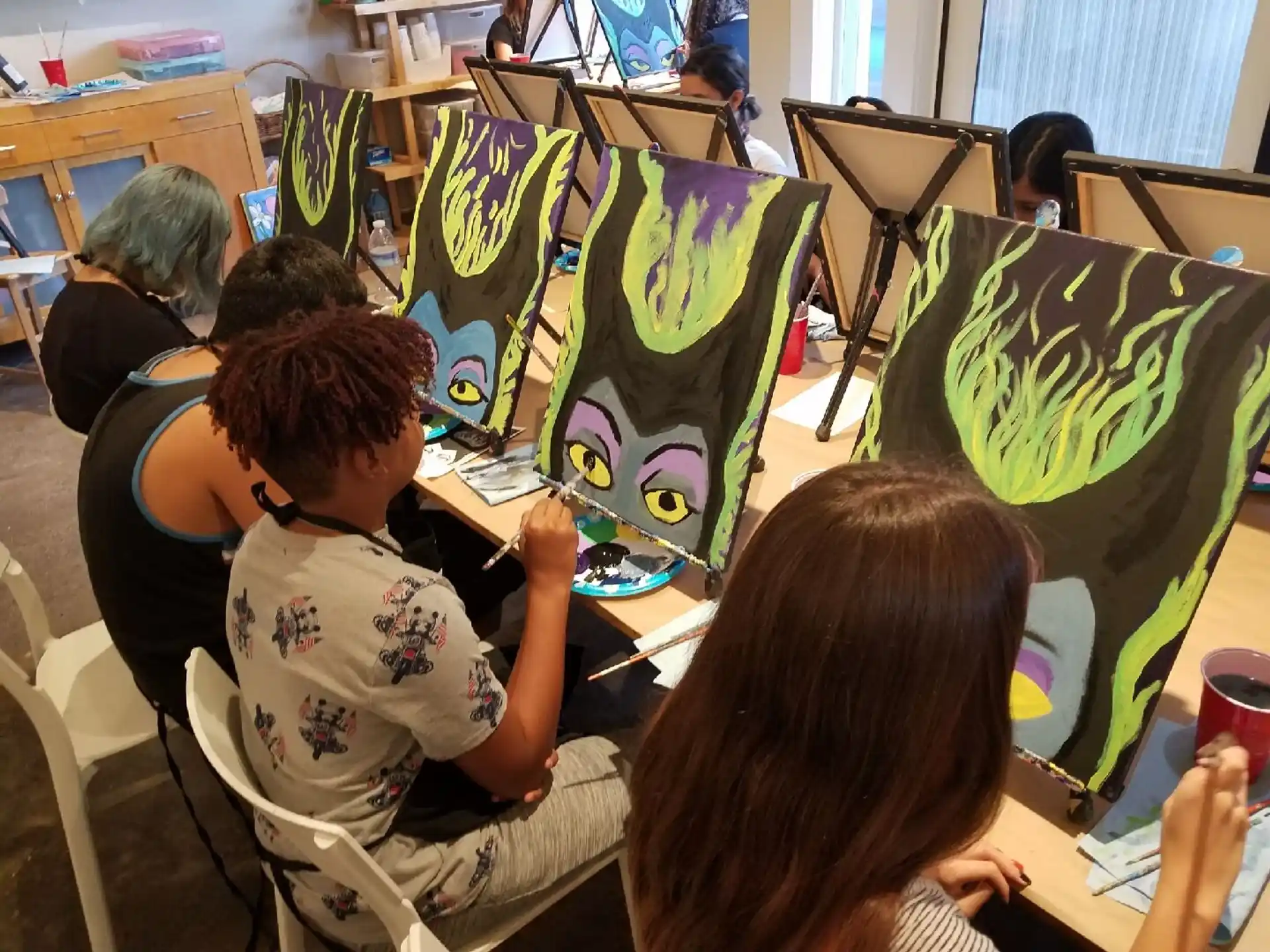 a group of people sitting at desks with a drawing on them