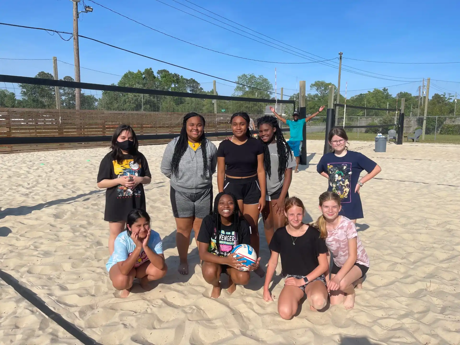 a group of people posing for a photo on a beach