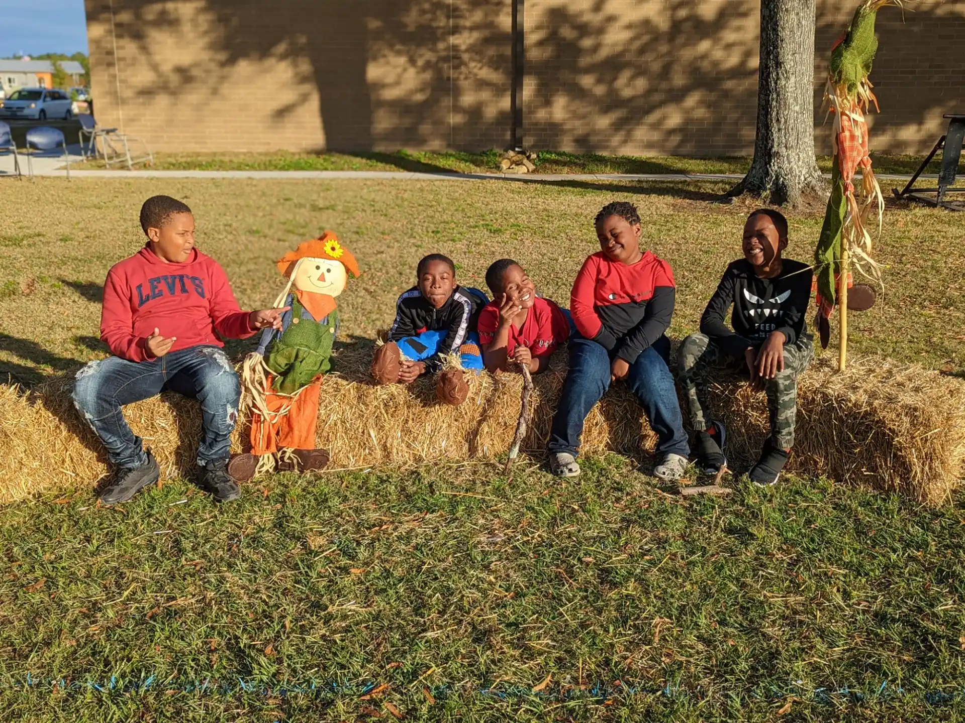 a group of people sitting on a rock in a grassy area