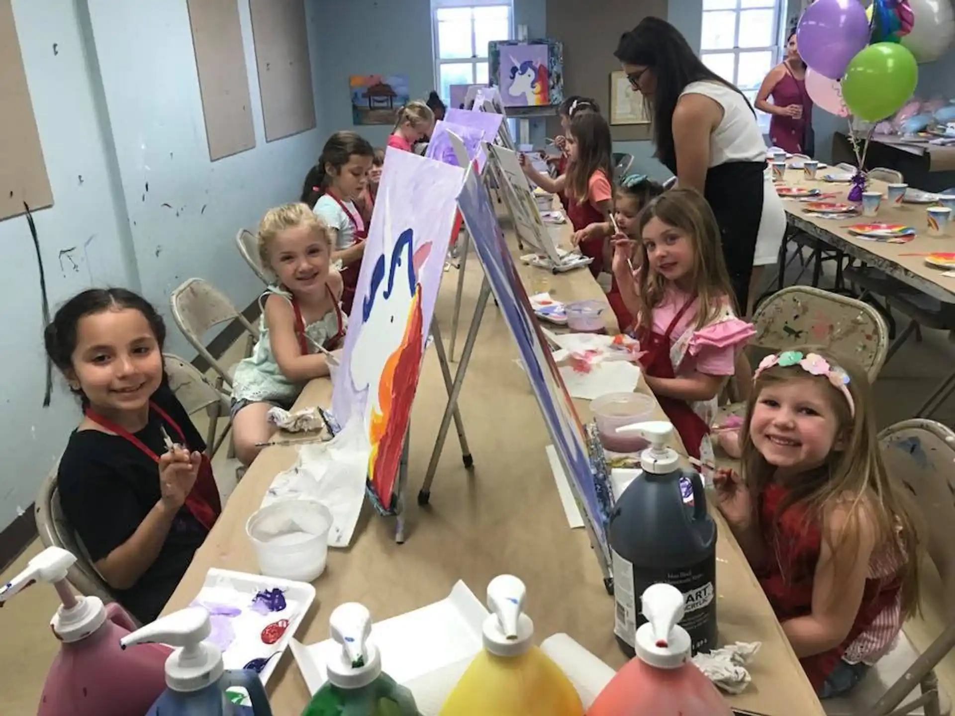 a group of children sitting at a table with a flag