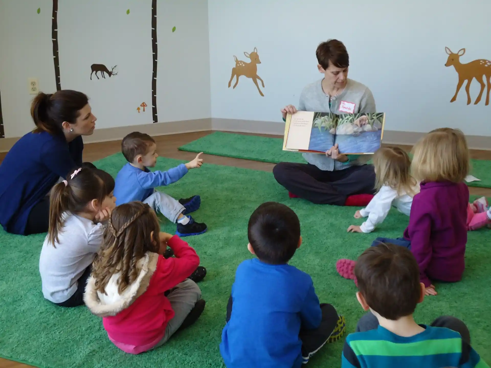 a person reading a book to a group of children