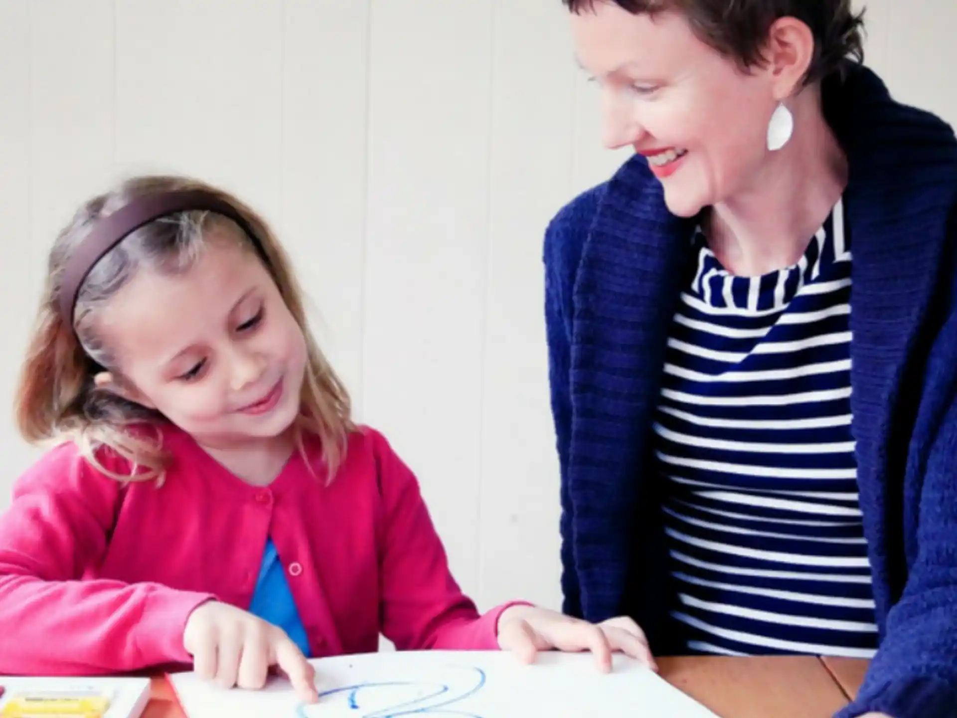 a person showing a girl something on a paper
