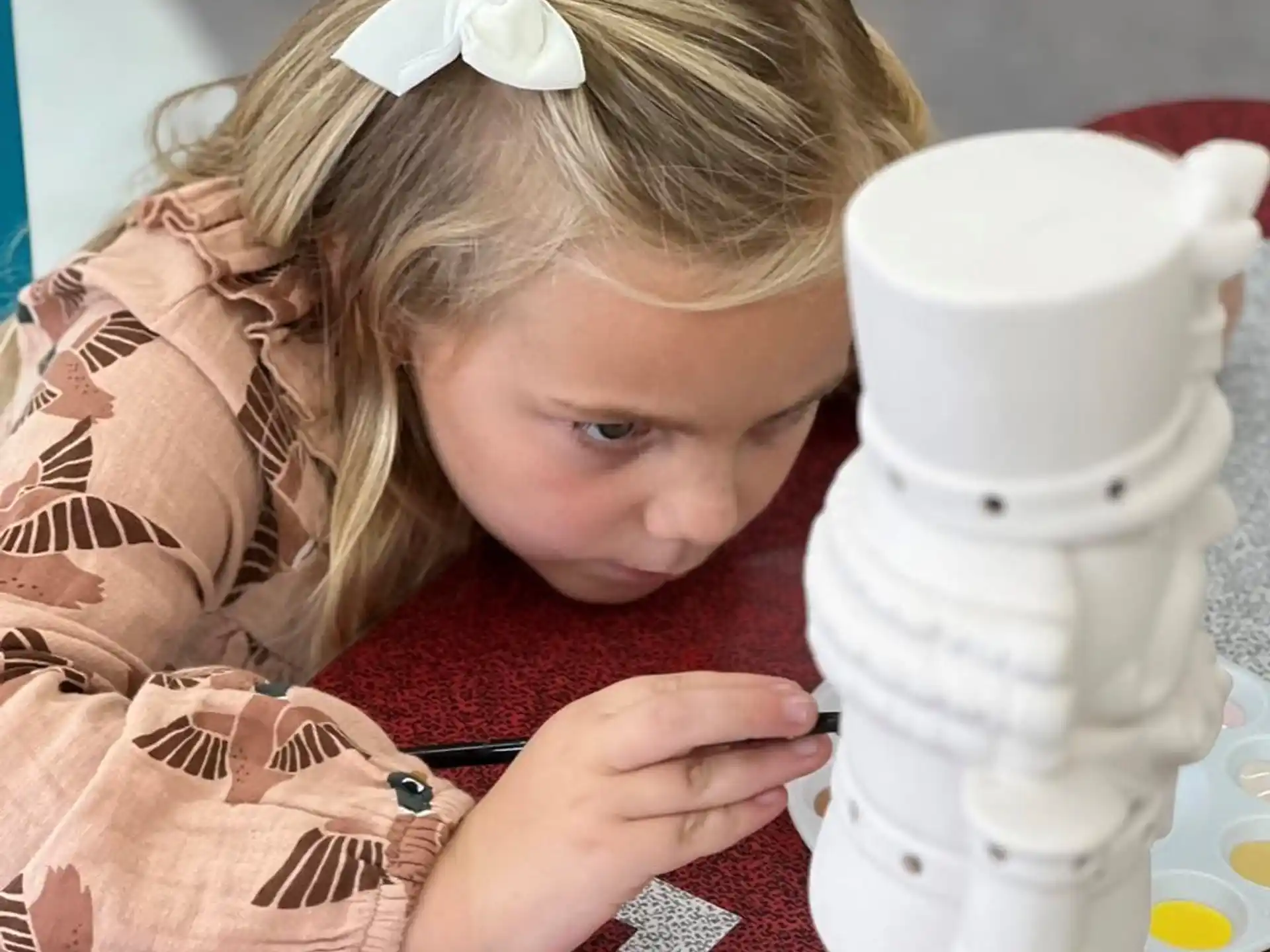a girl looking at a white mug
