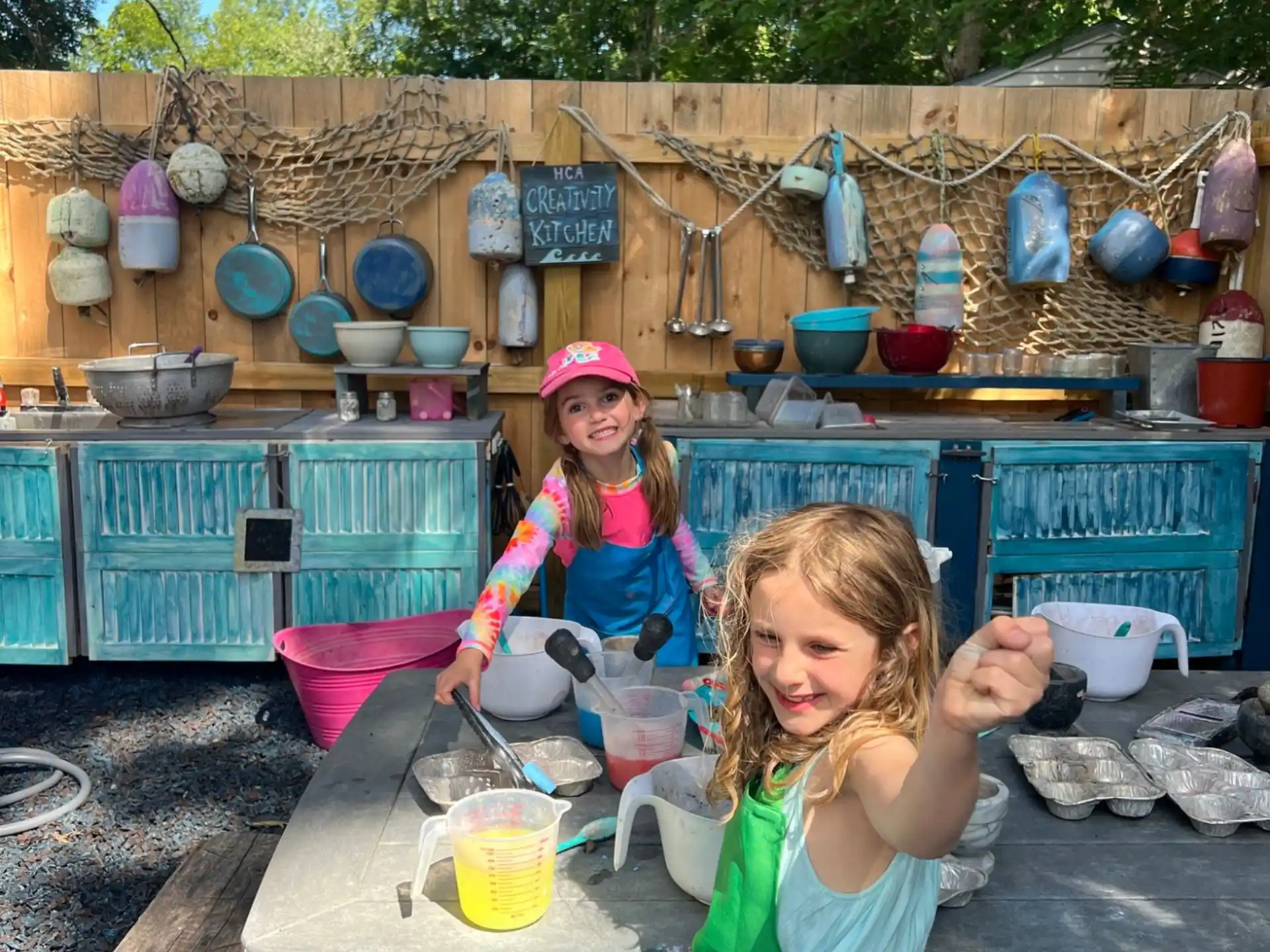 a couple of girls sitting at a table with food and bowls