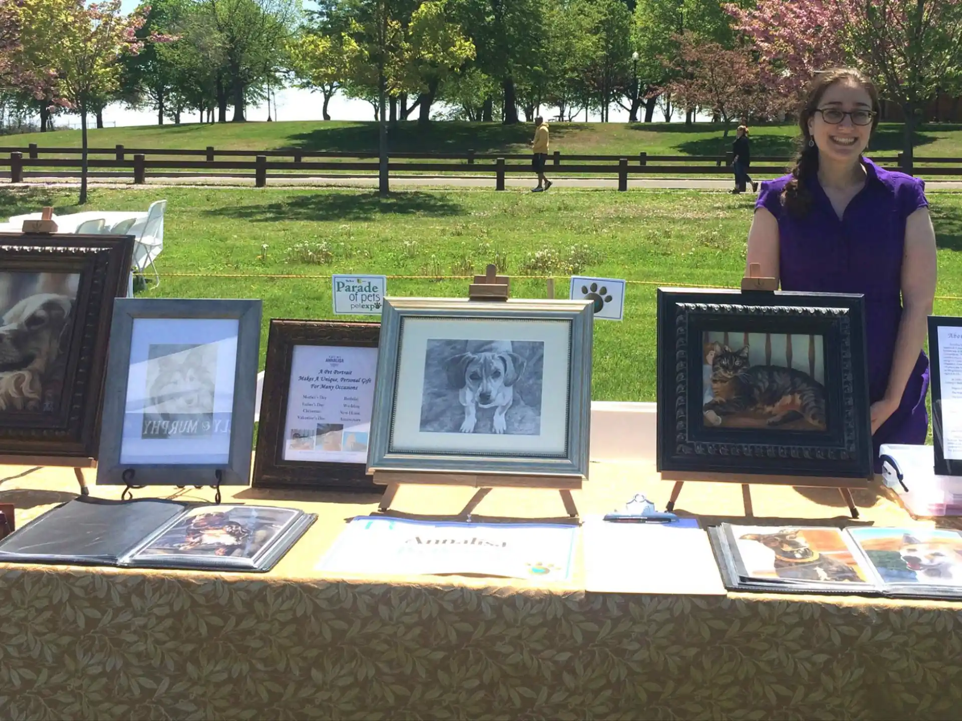 a person standing next to a table full of framed pictures