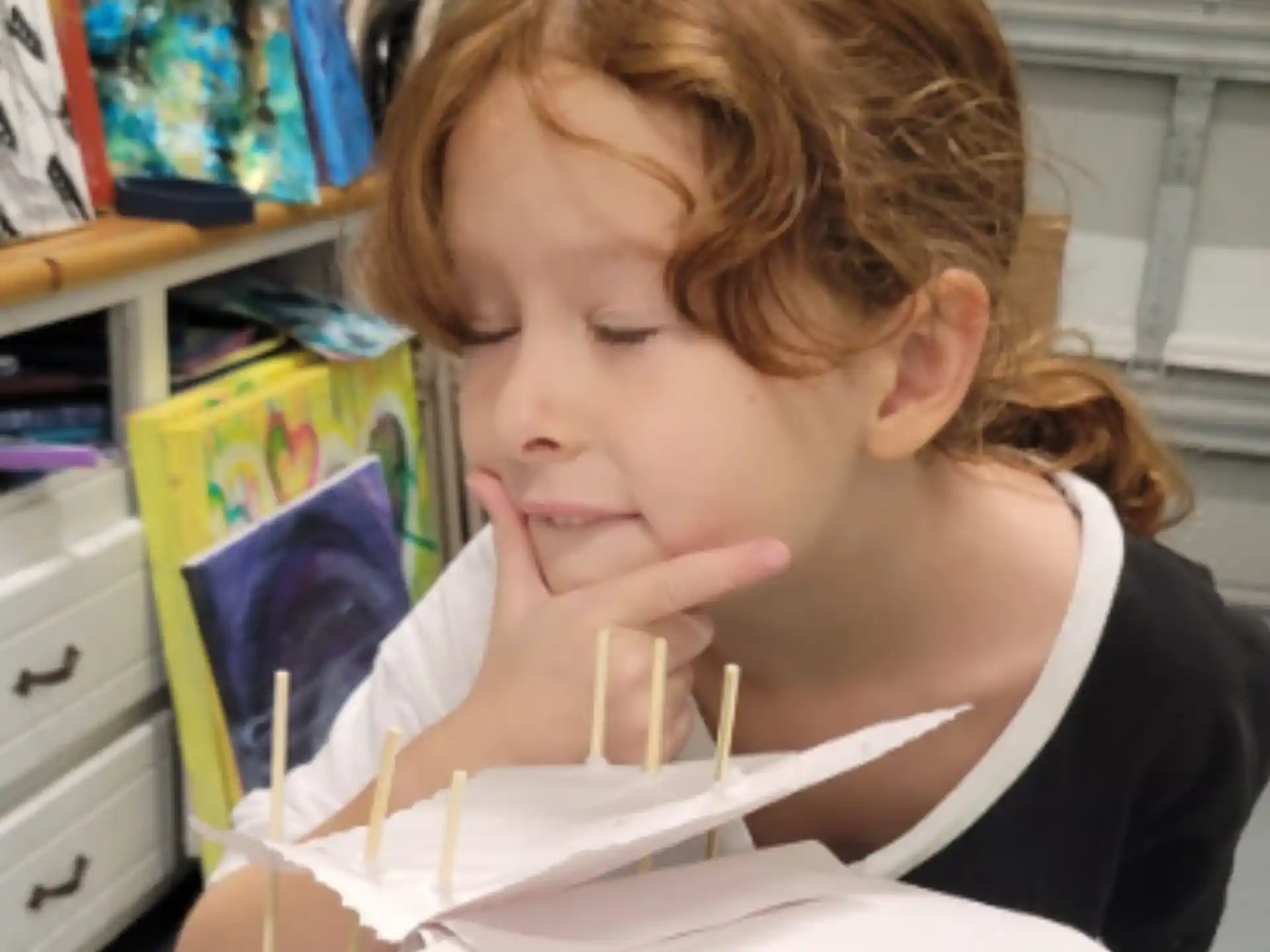 a young girl holding a pencil