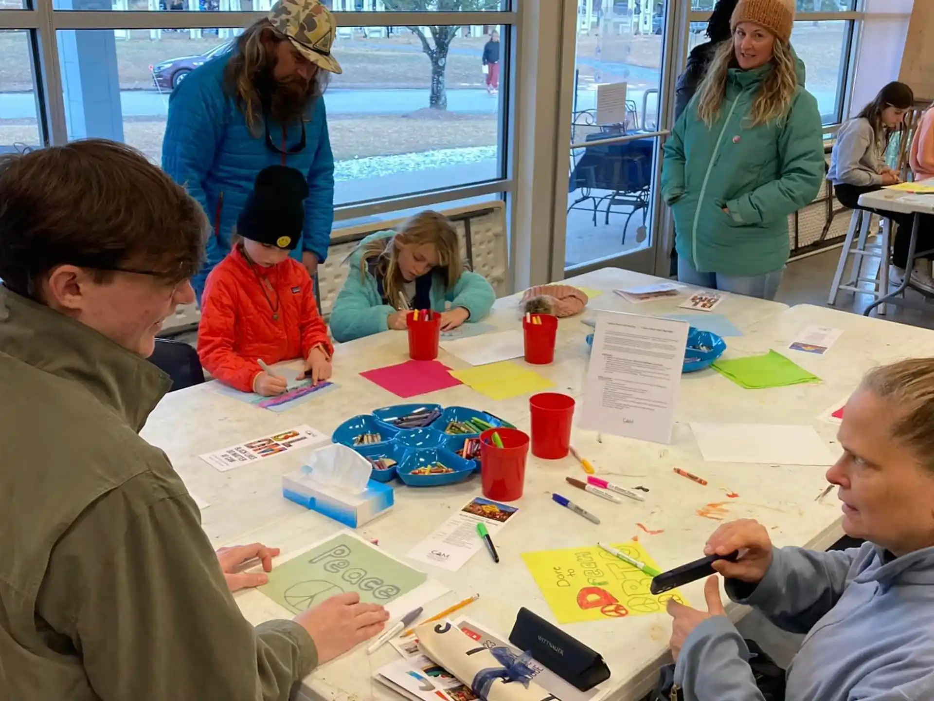 a group of people sitting at a table with papers and pens