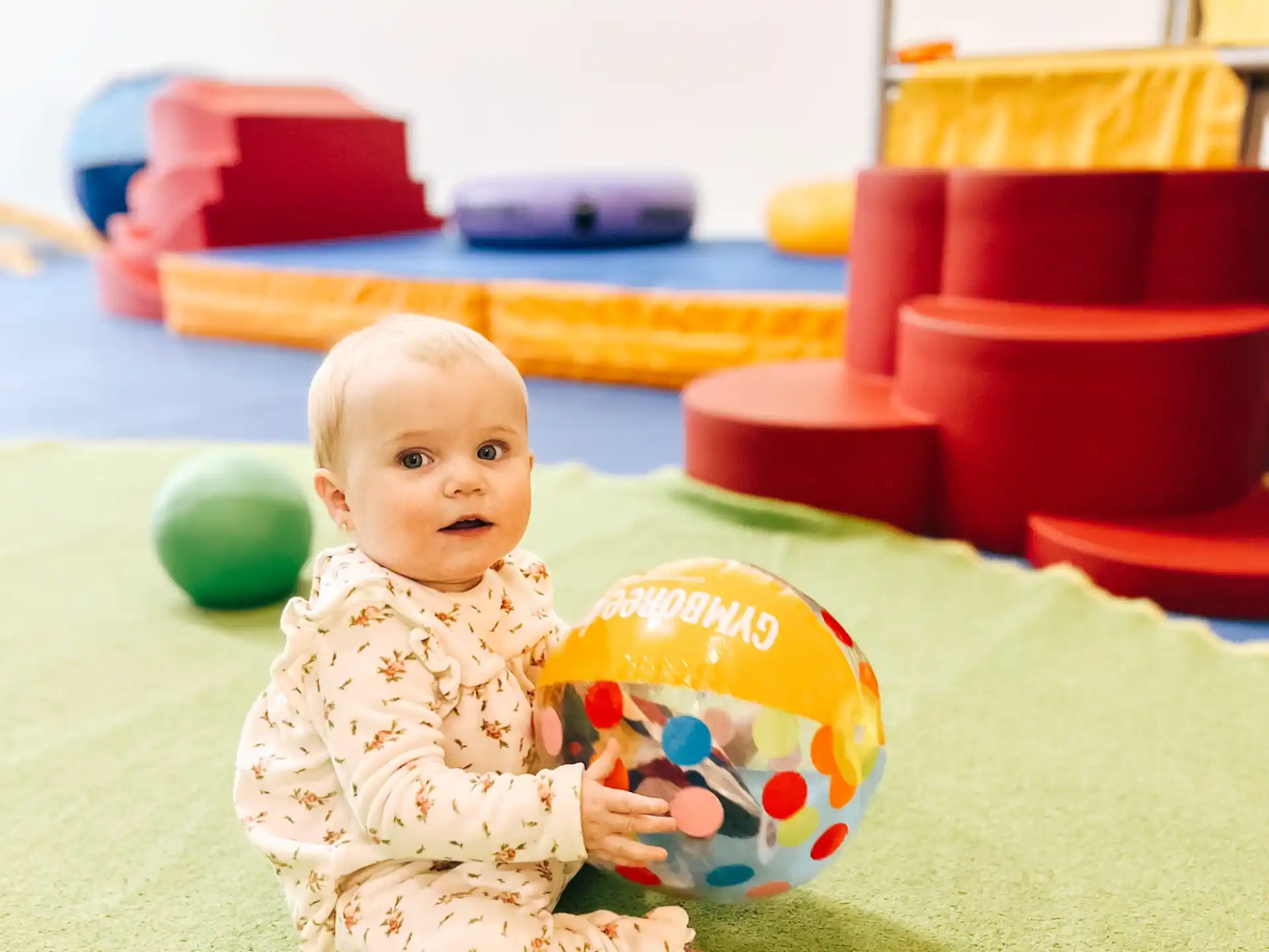 a baby sitting on the floor with a toy
