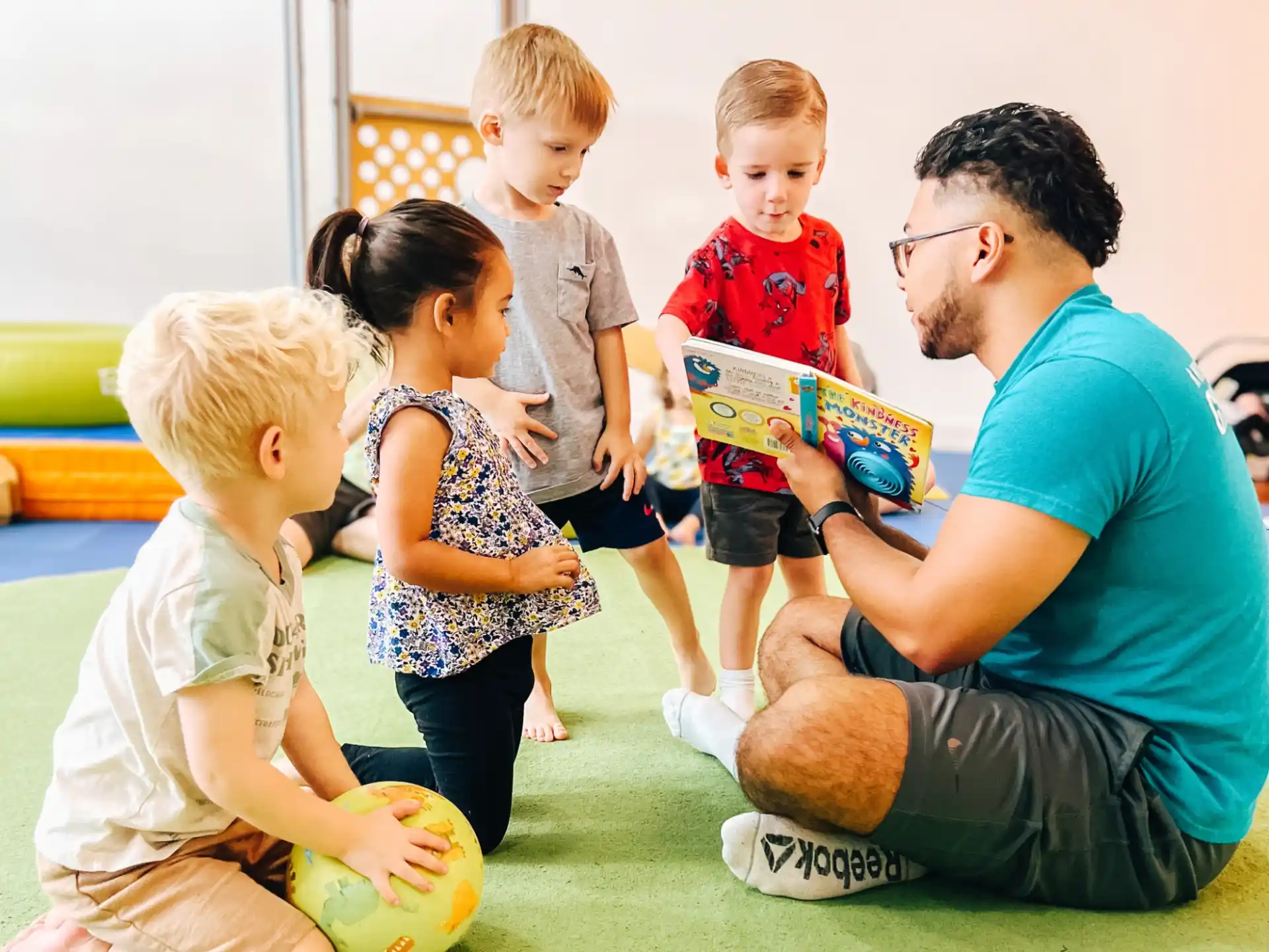 a person reading a book to a group of children
