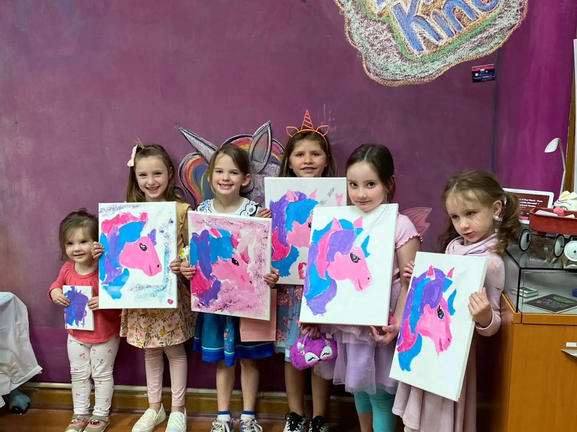 a group of children holding up colorful paper signs
