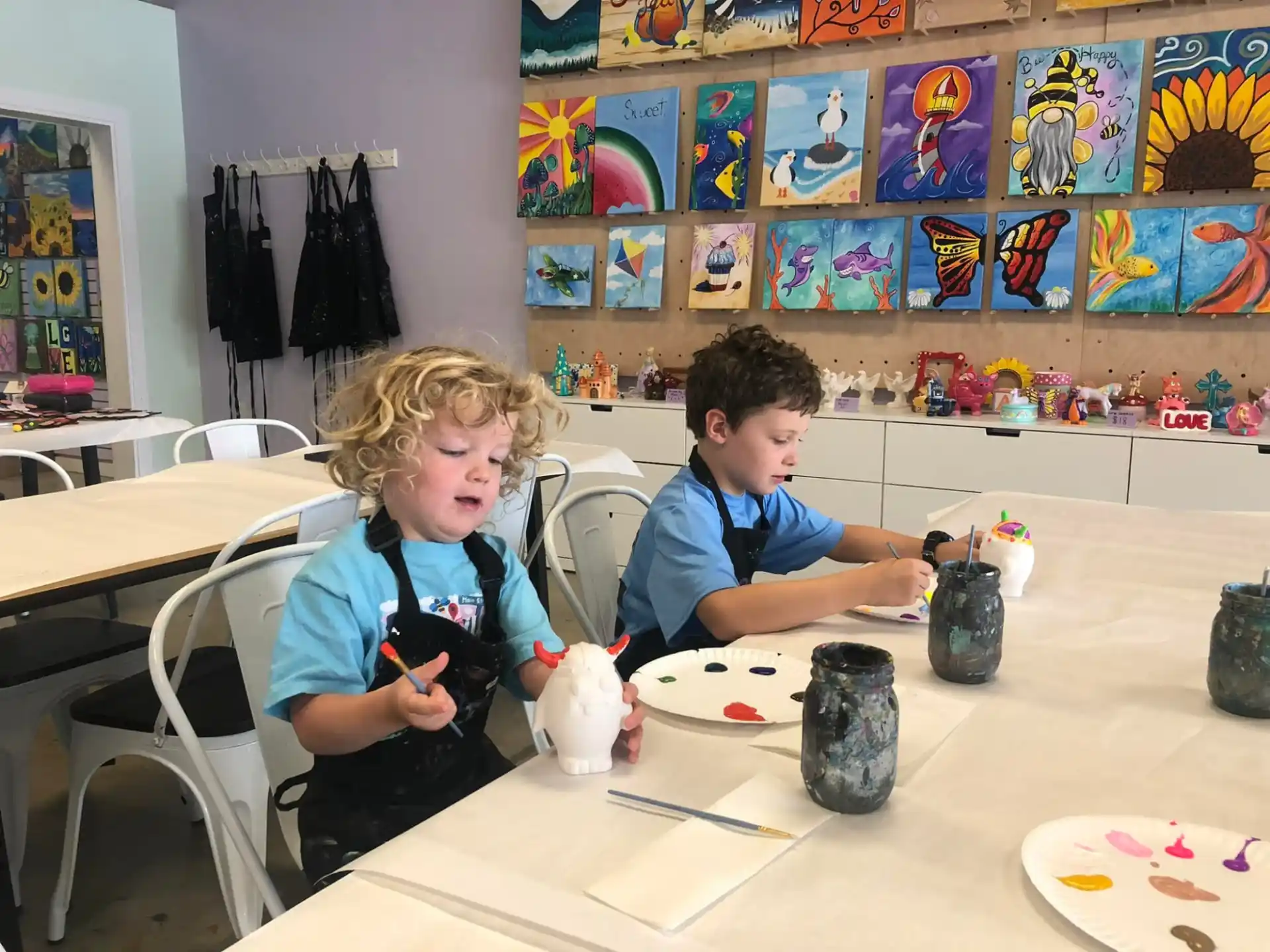 a couple of boys sitting at a table with a camera