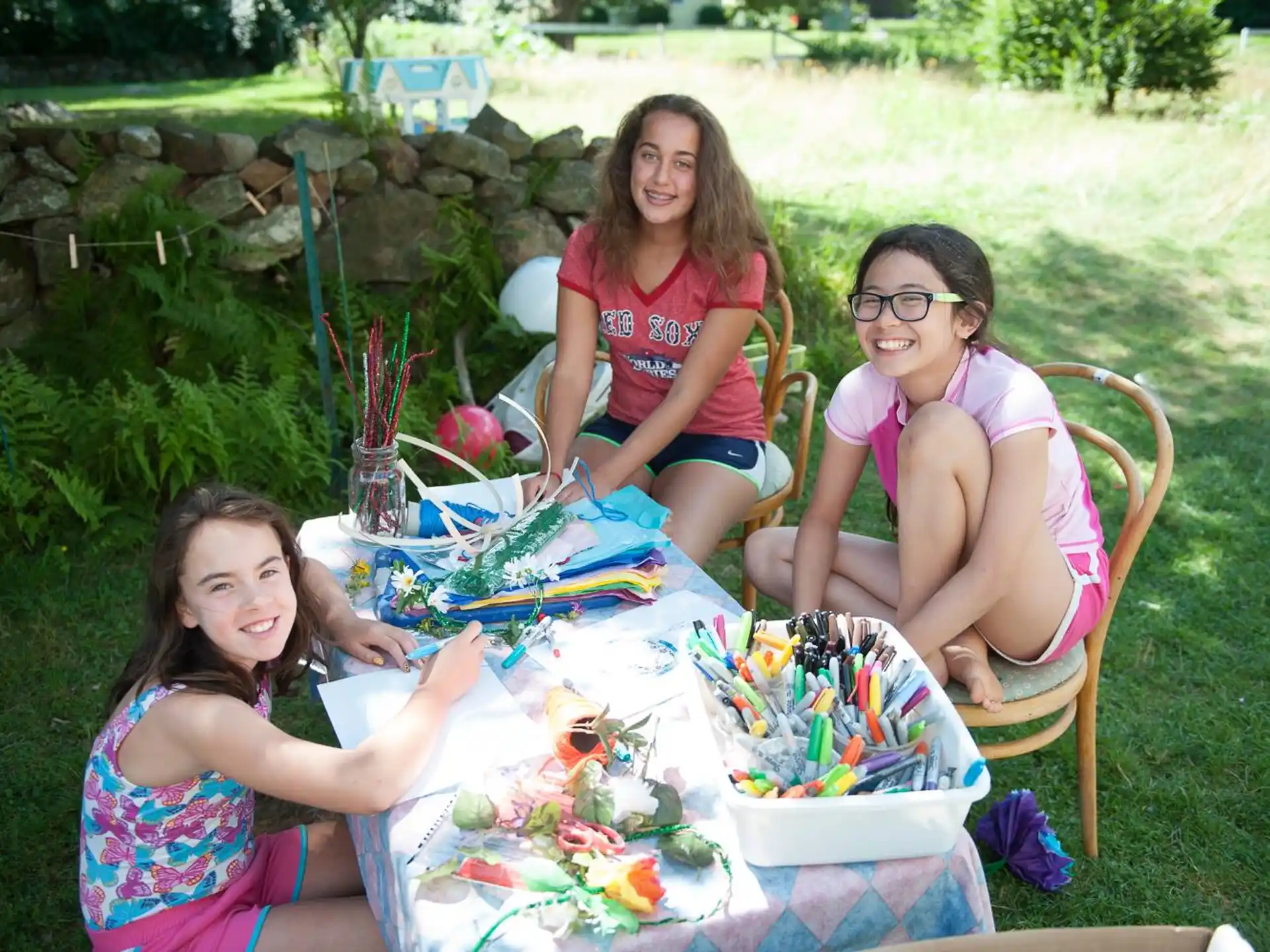 a group of women sitting in chairs outside