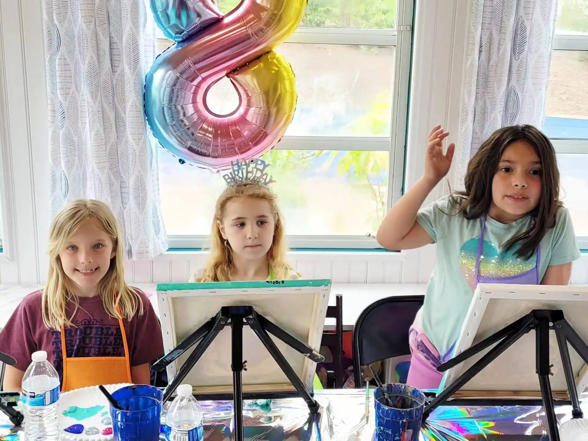 a group of girls sitting at a table with a balloon