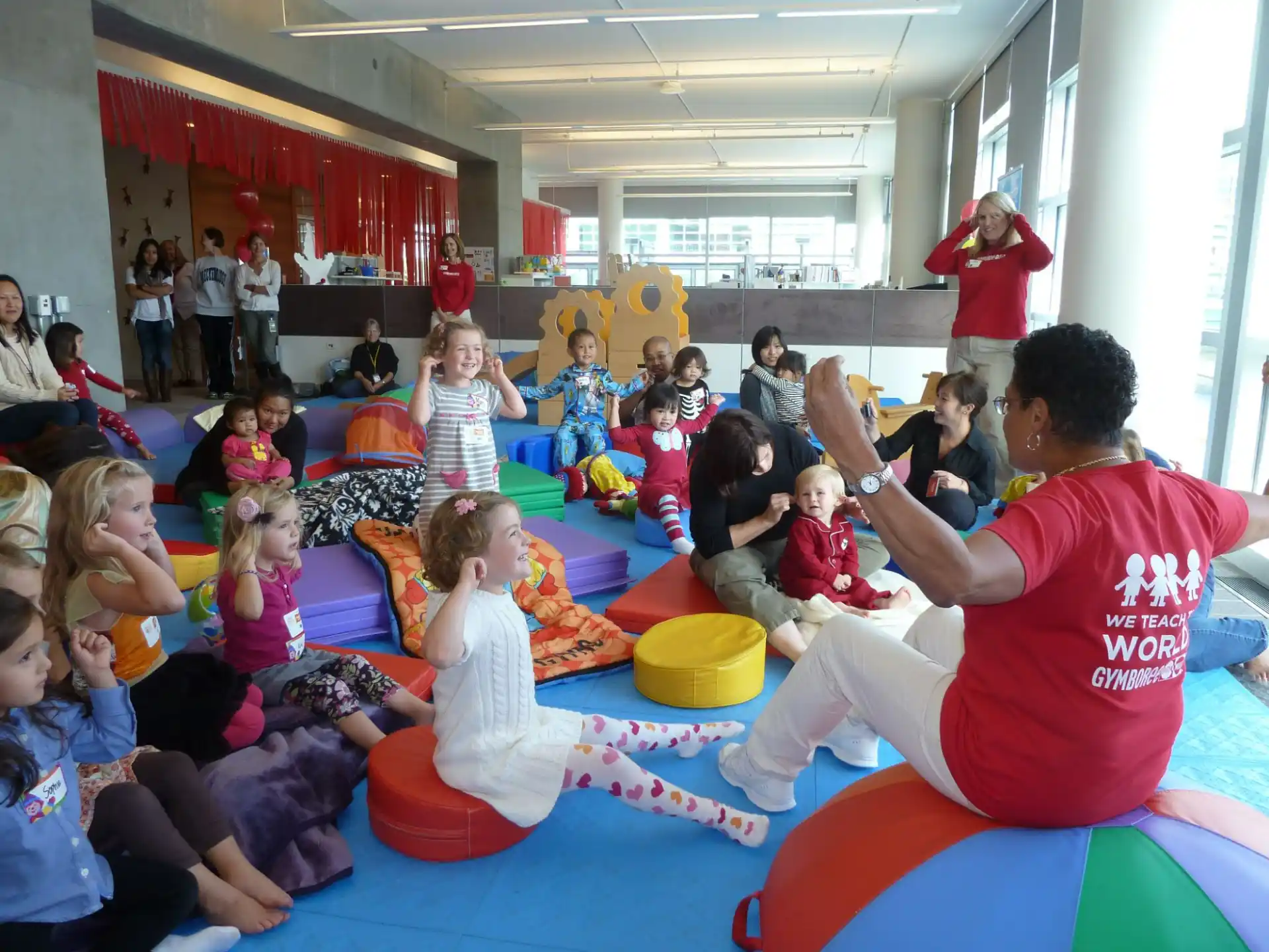 a group of people sitting on colorful mats in a room