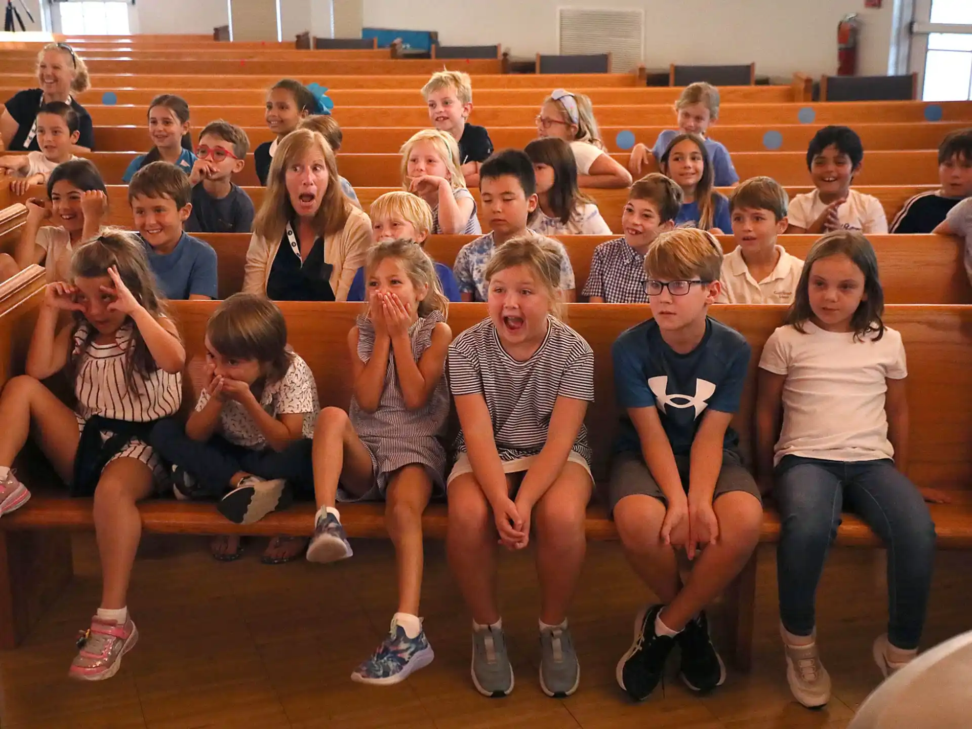 a group of children sitting in a lecture hall