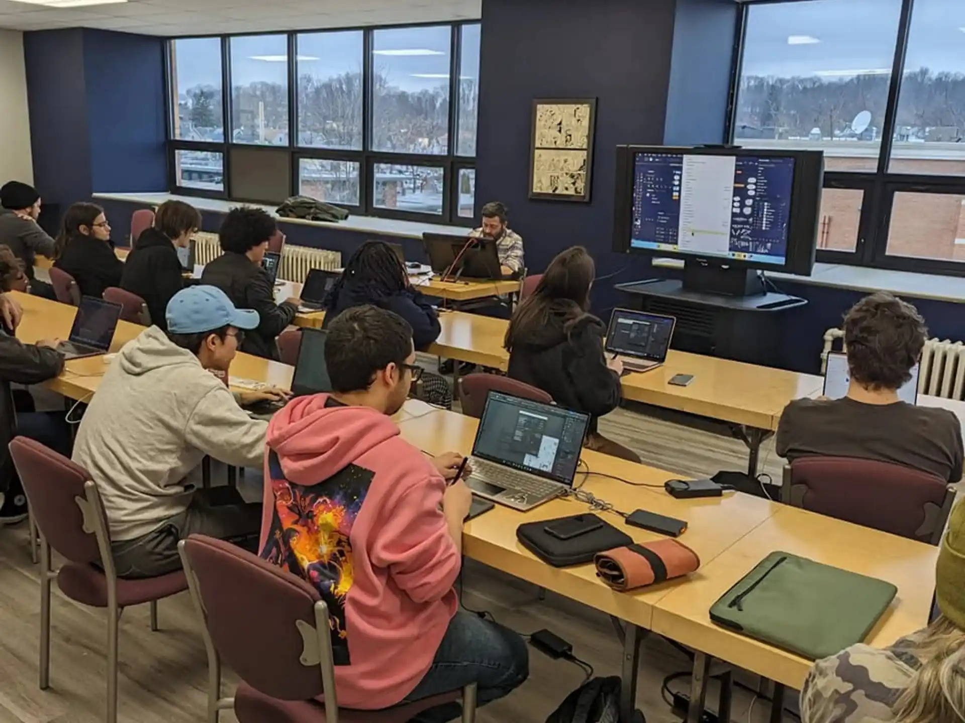 a group of people sitting at desks with laptops