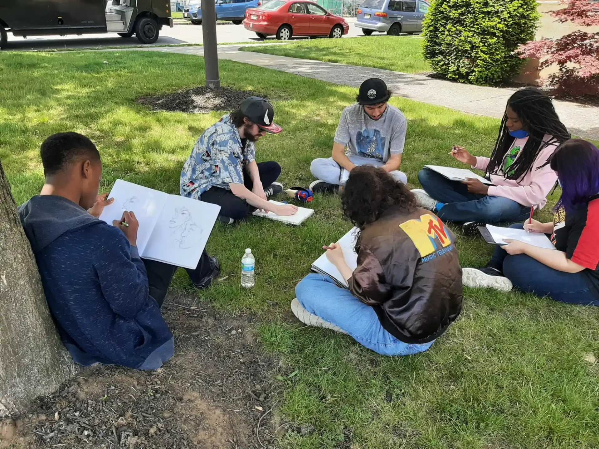 a group of people sitting on the grass