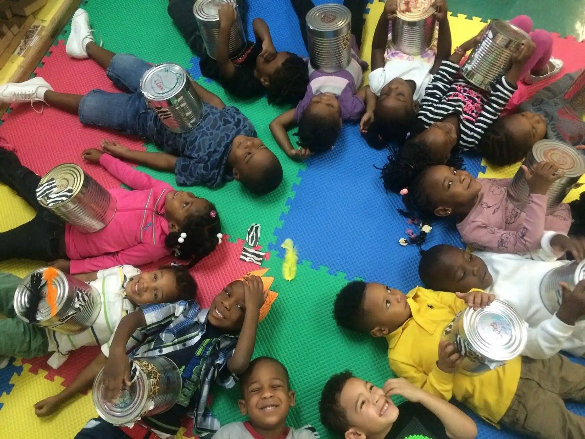 a group of children lying on the ground with their hands on their heads