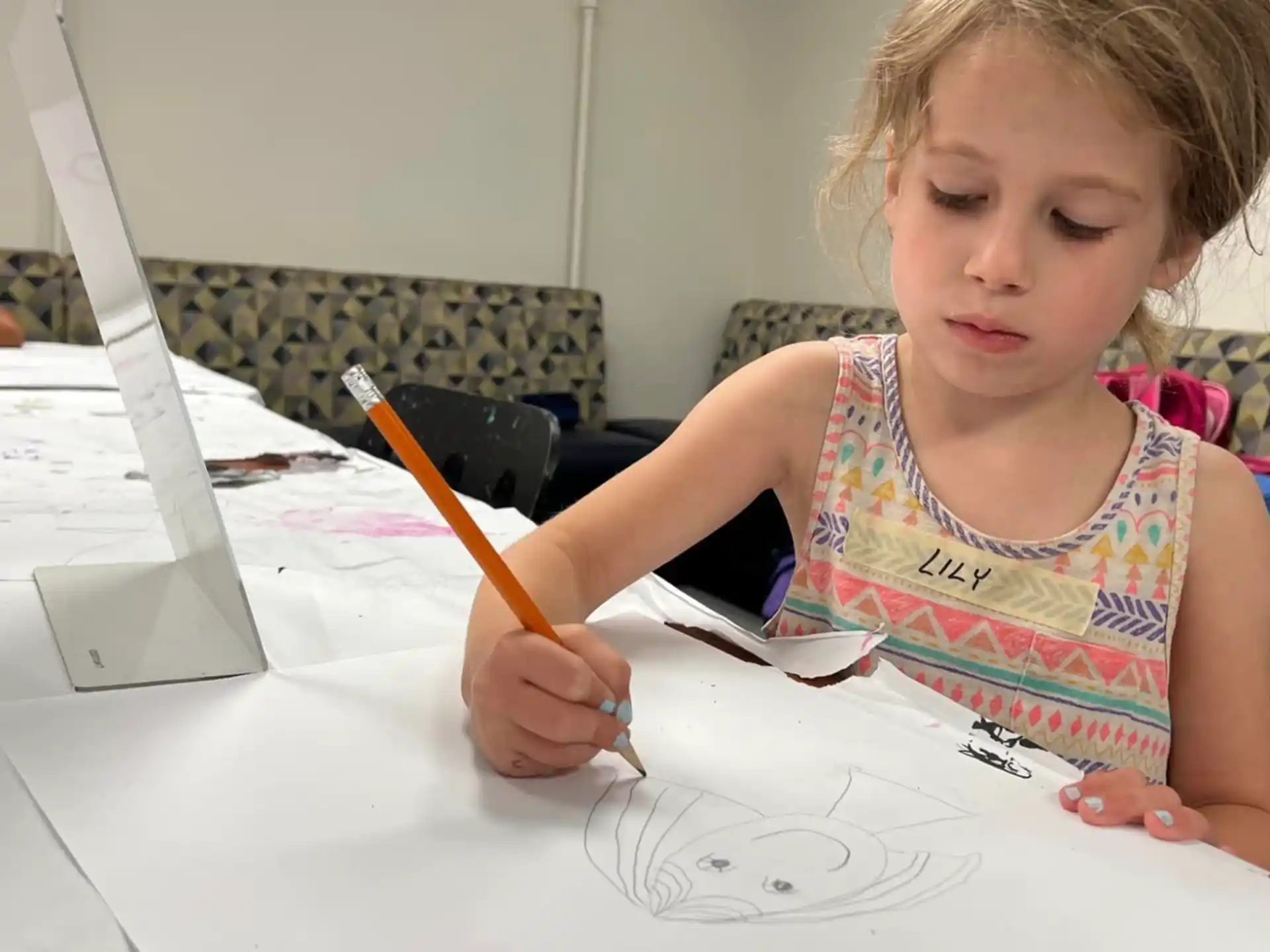 a young girl drawing on a white paper