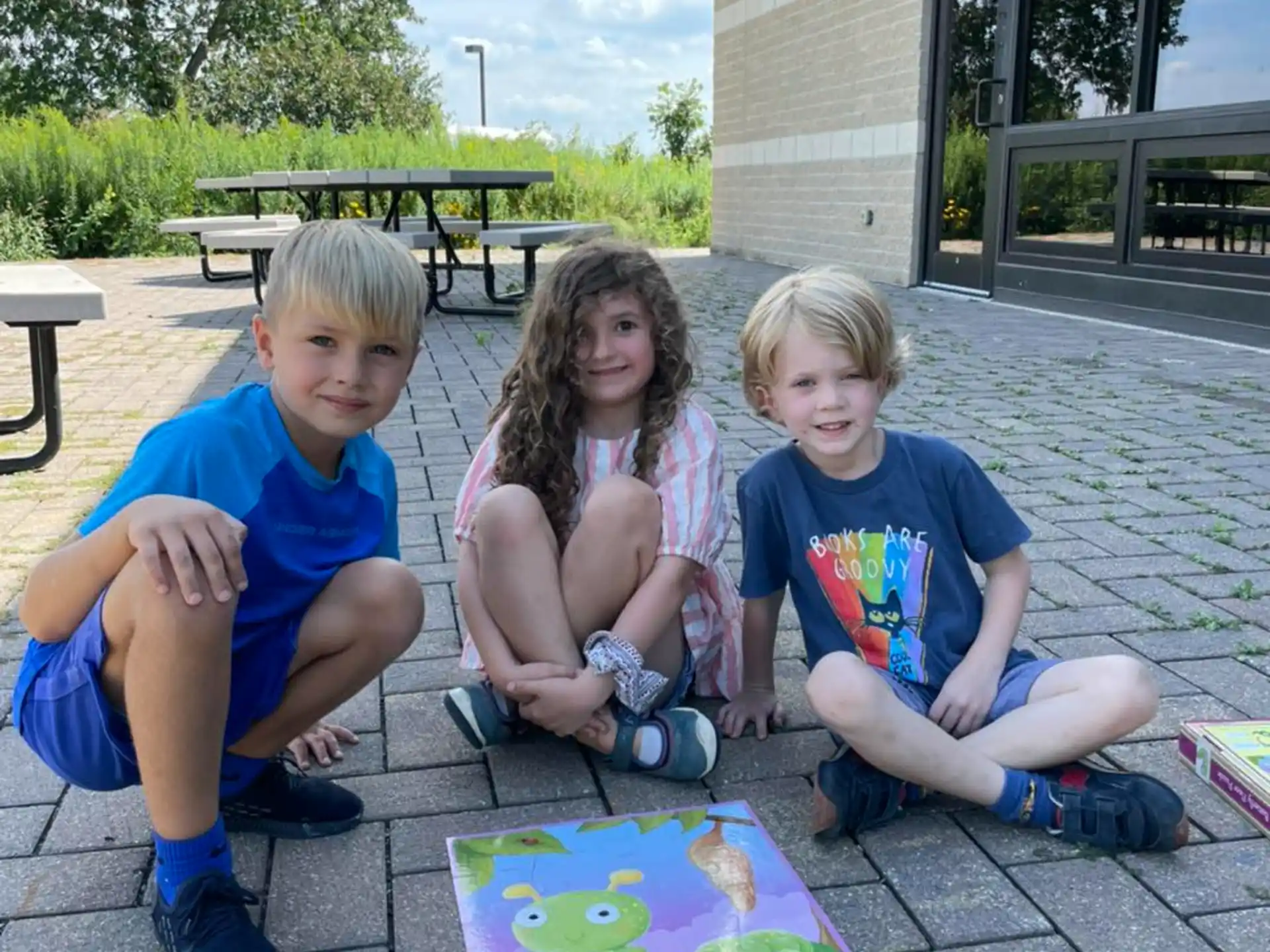 a group of children sitting on the ground outside