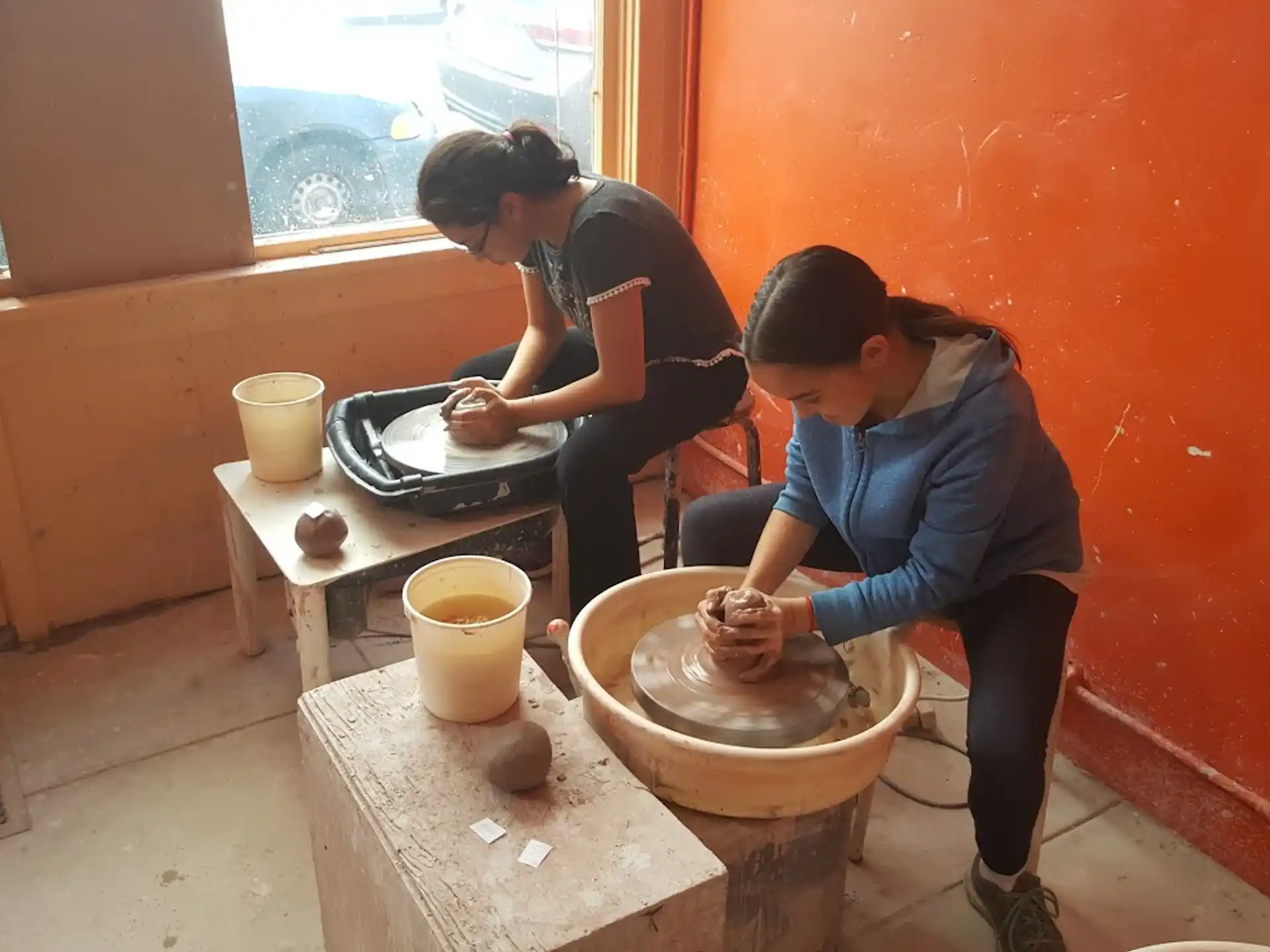 a couple of women making clay pots