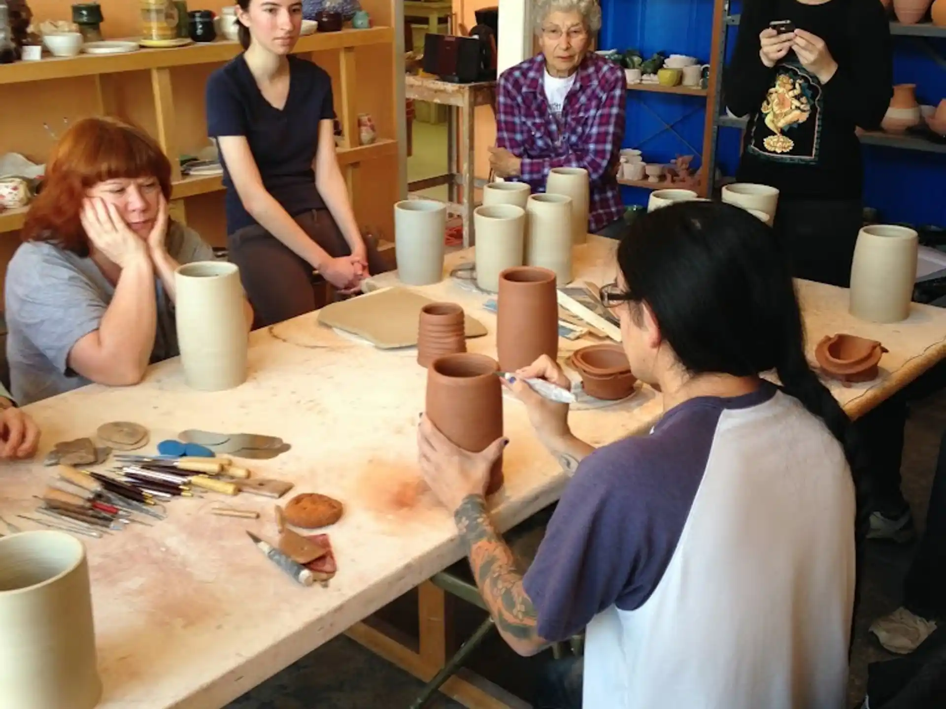 a group of people sitting around a table with cups on it