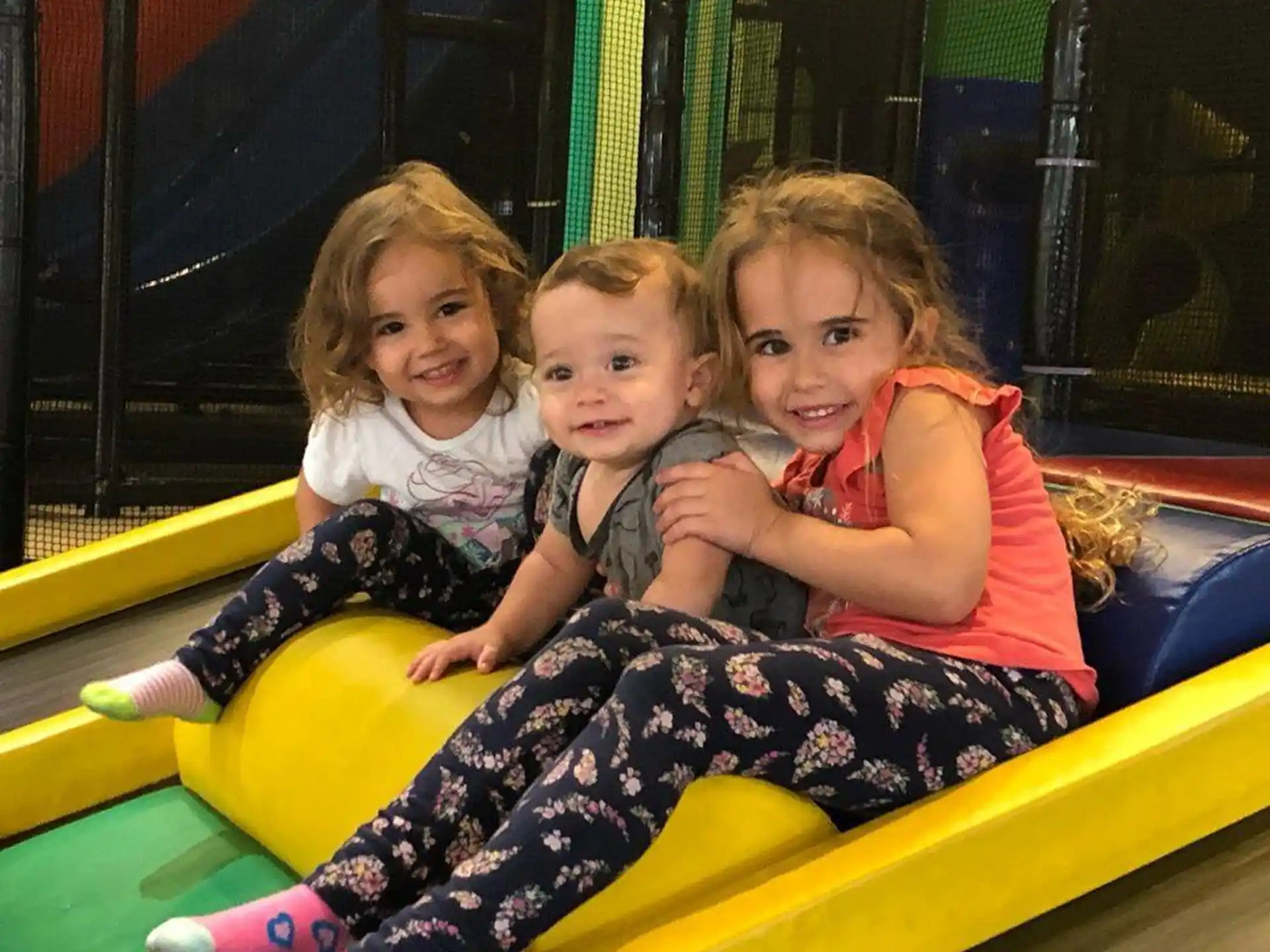 a group of children sitting on a yellow slide
