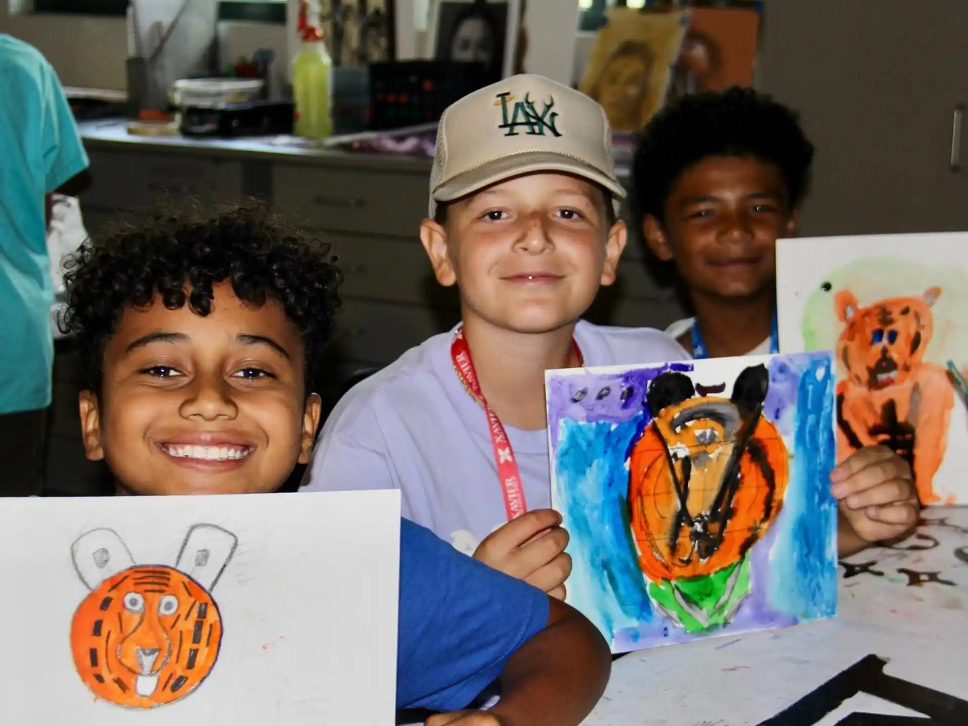 a group of boys holding up drawings