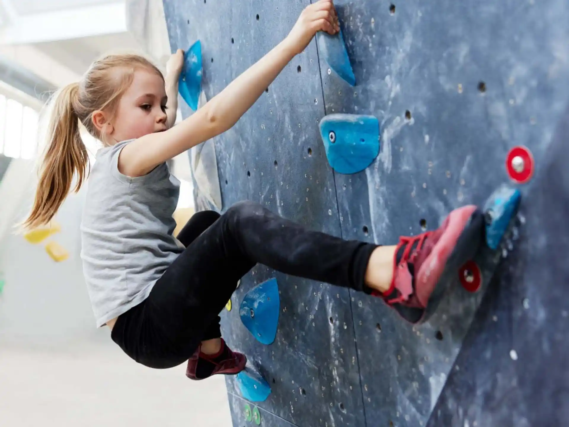 a girl climbing a rock wall