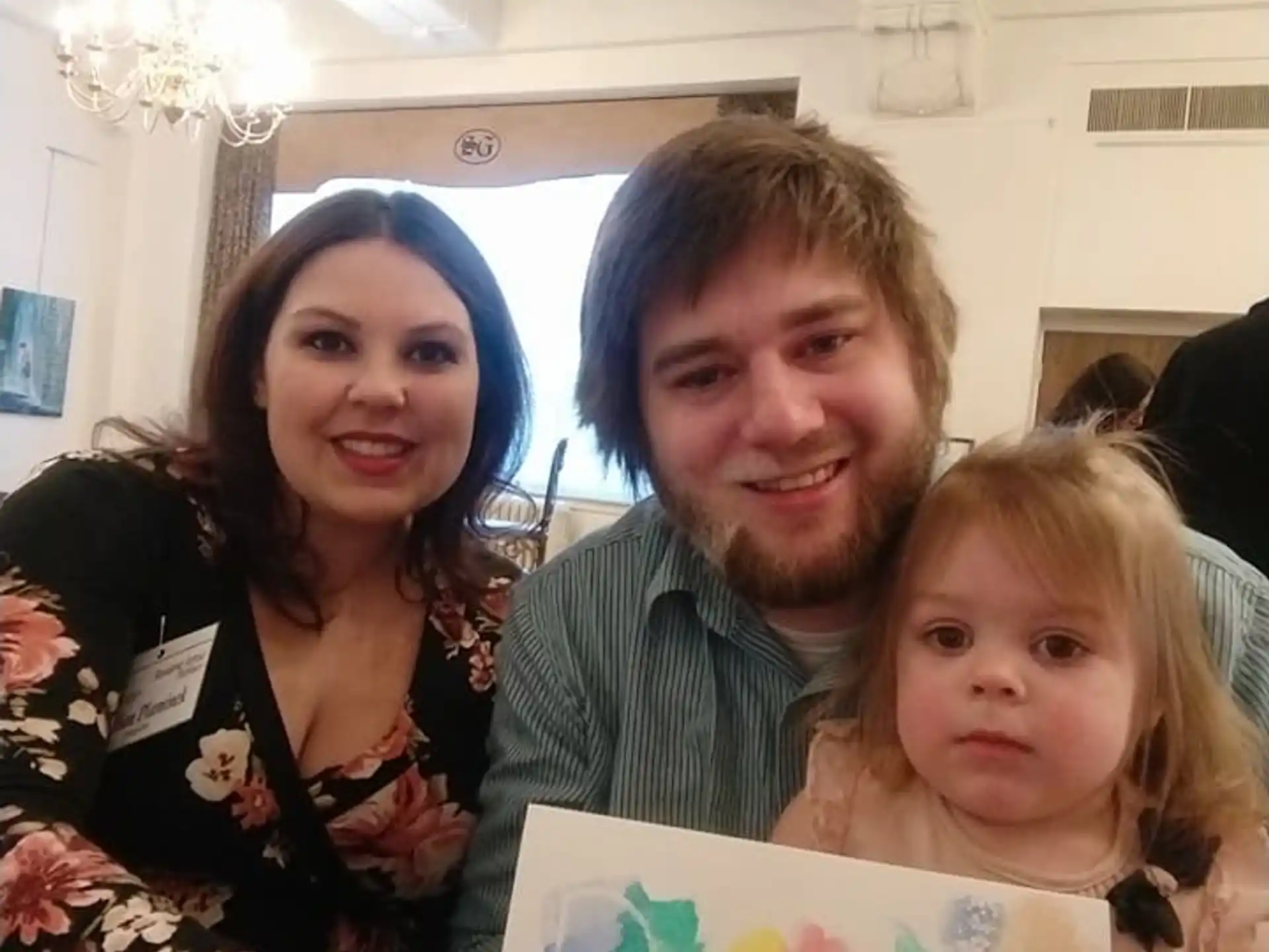 a man and woman holding a baby