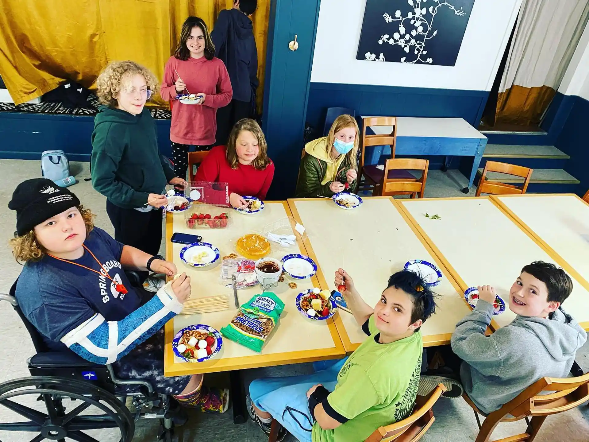 a group of children sitting around a table eating food