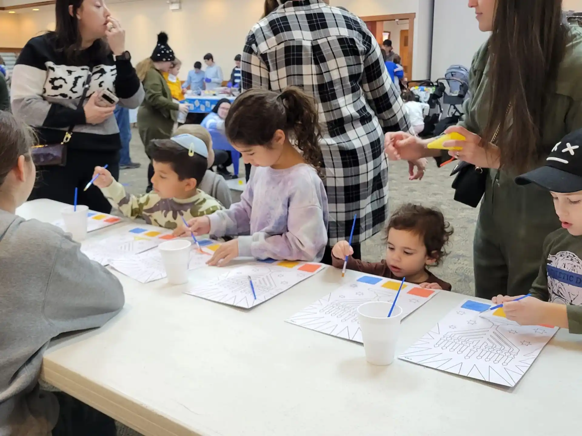 a group of children sitting at a table writing on paper