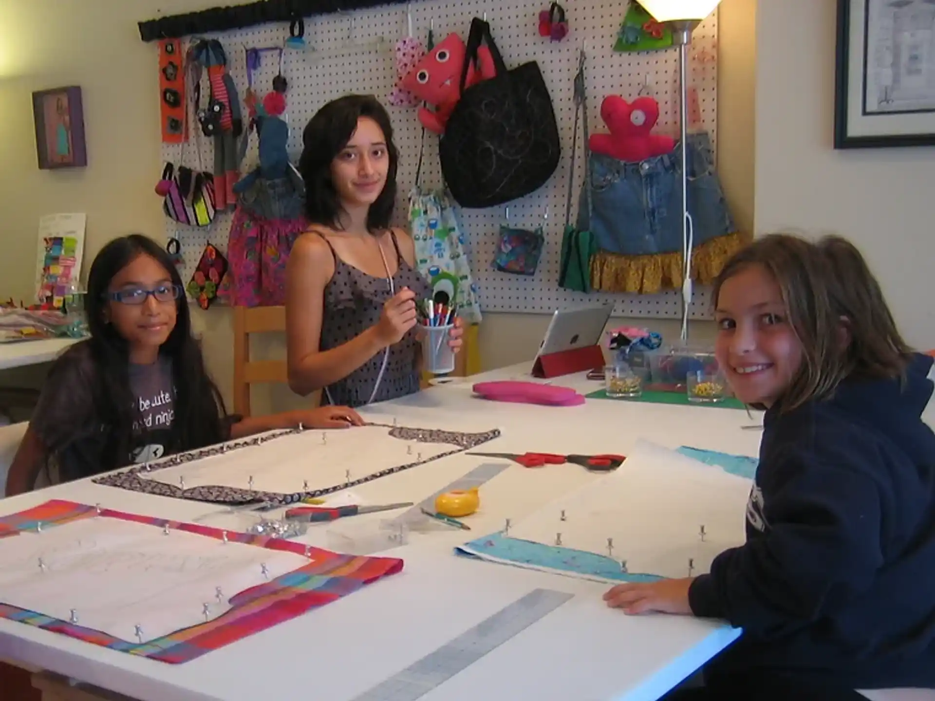 a group of women sitting at a table with art on the wall