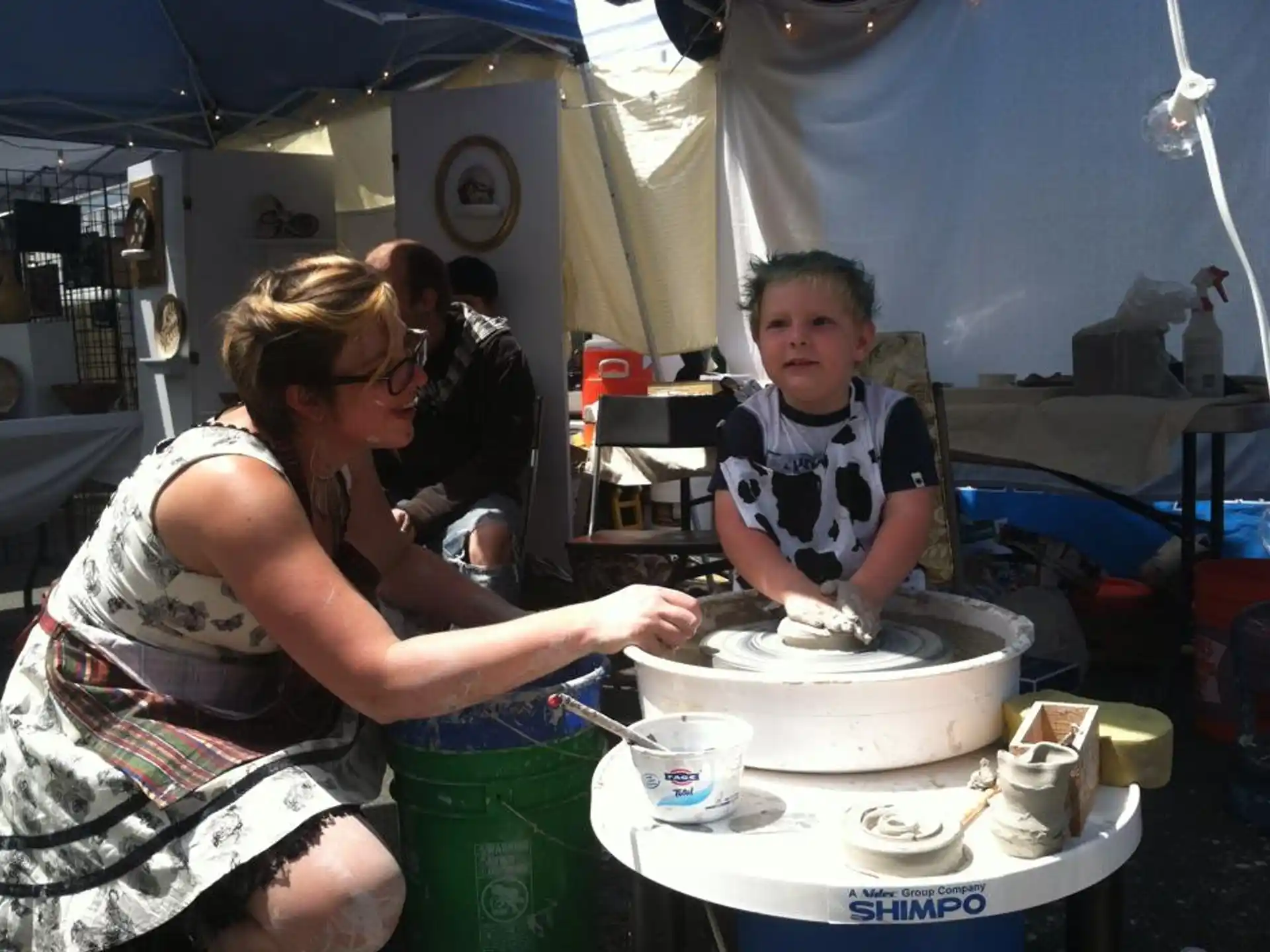 a woman and a boy cooking in a tent