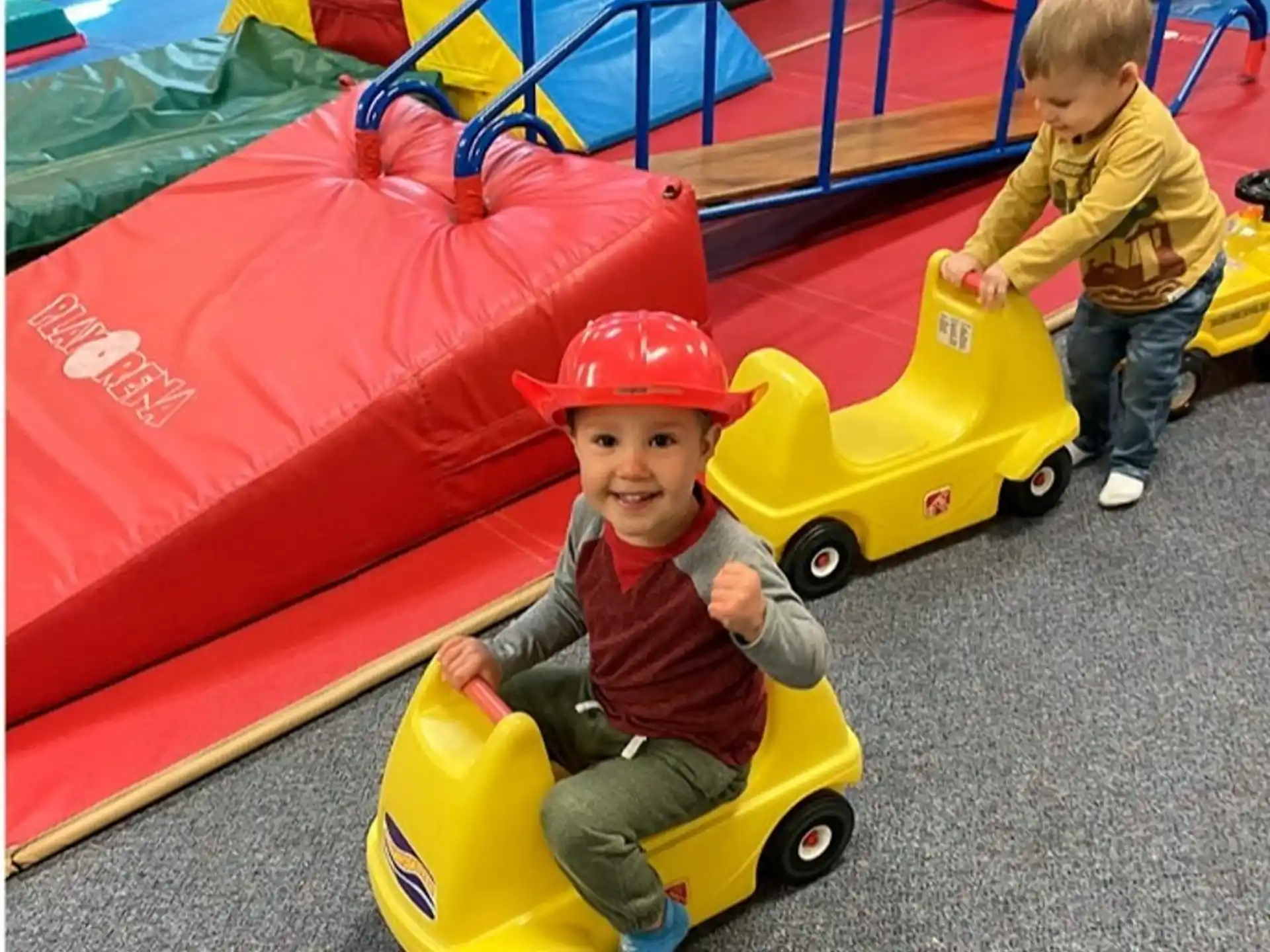 a couple of kids playing on a toy car
