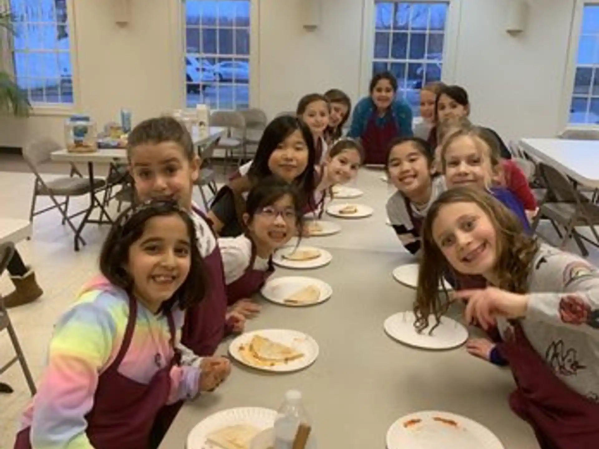 a group of people sitting at a table eating food