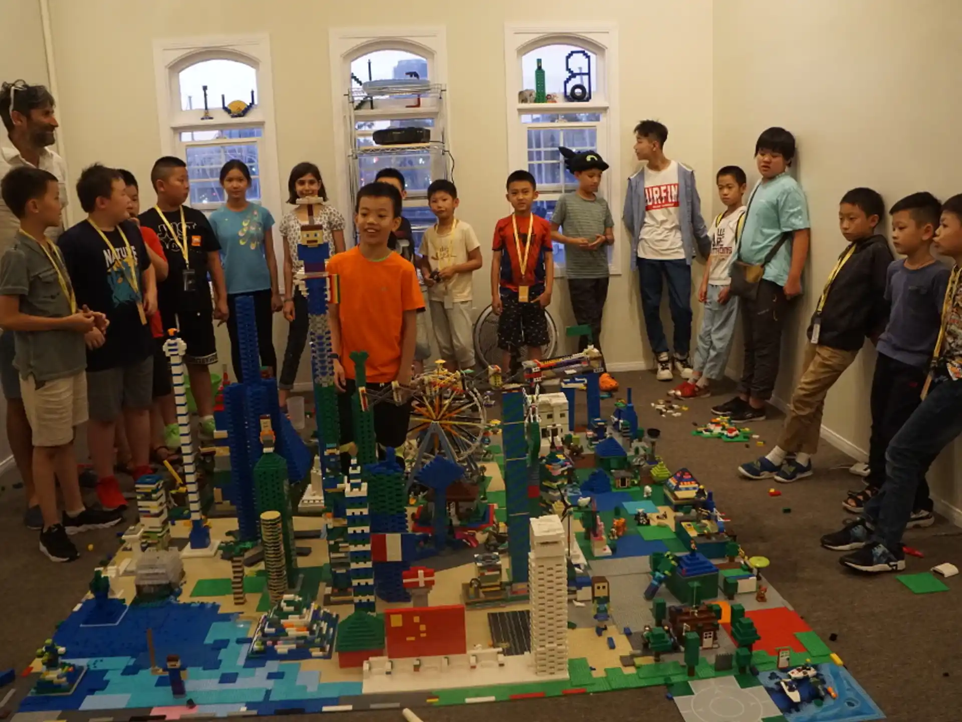 a group of people standing around a model train track