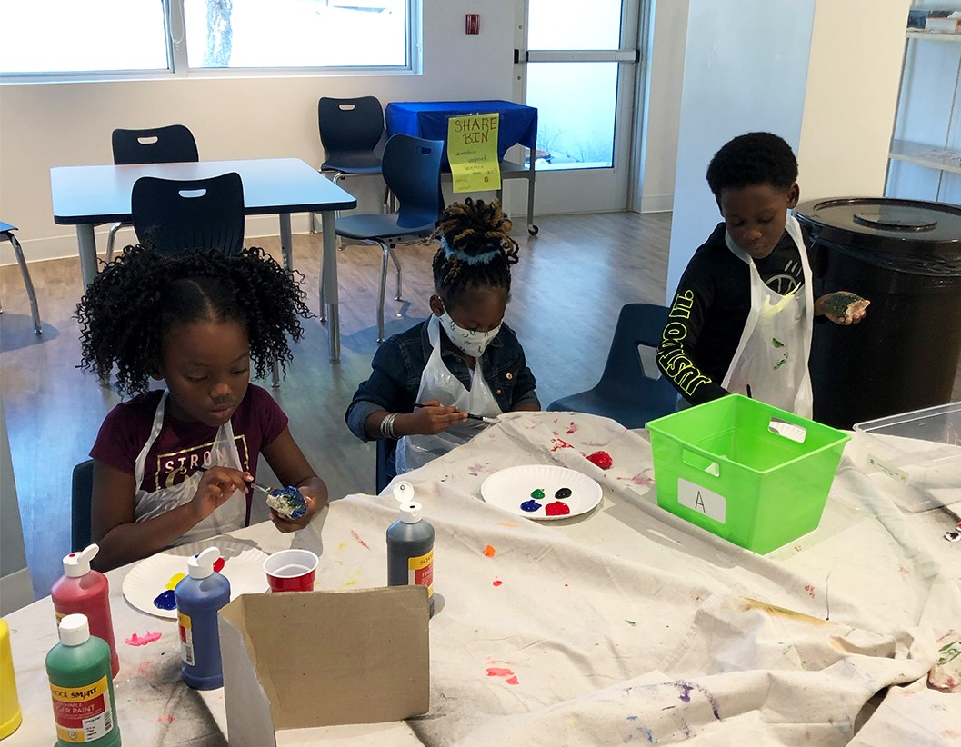 a group of children sitting at a table with a white tablecloth