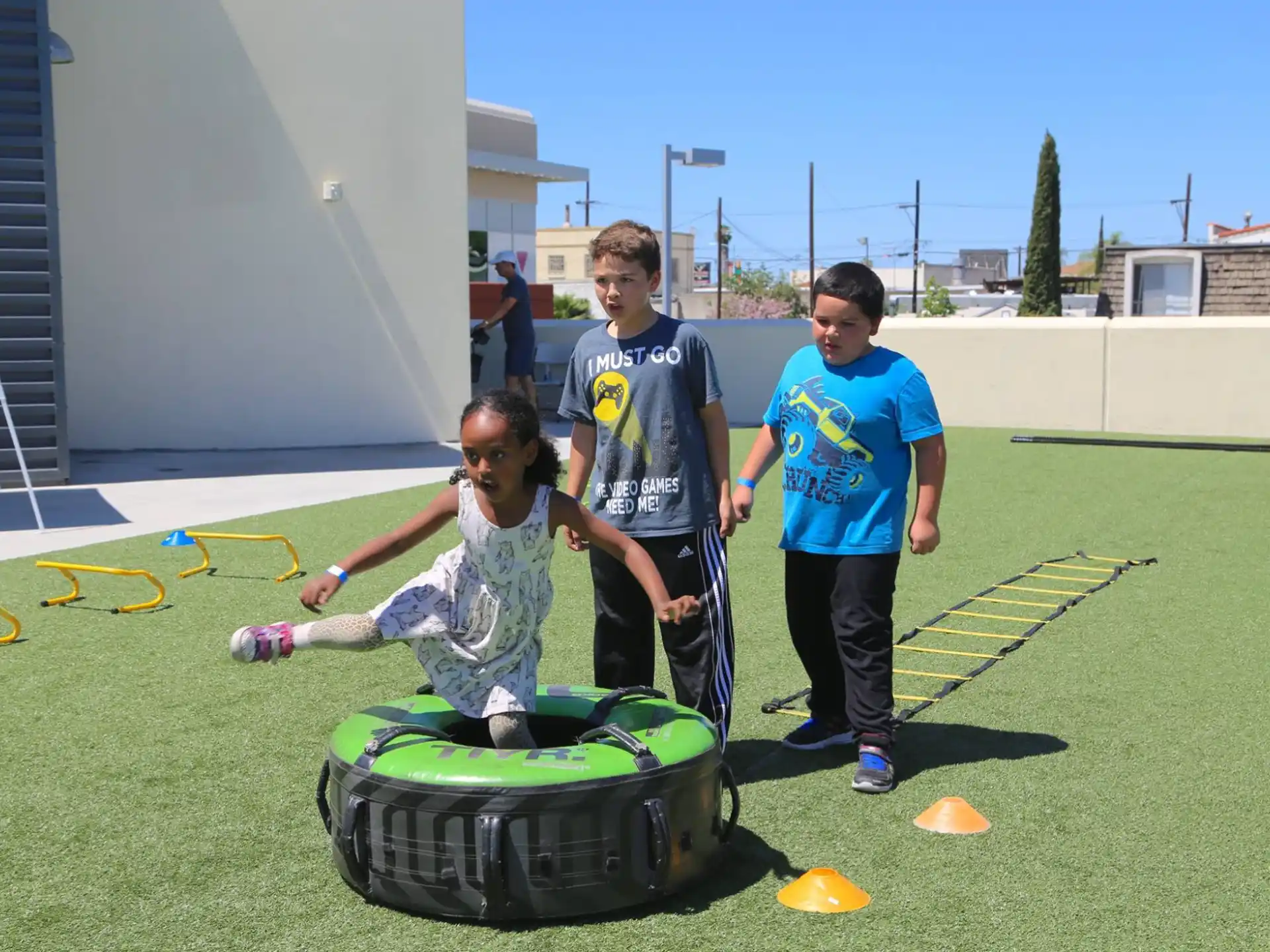 a group of boys standing around a green lawnmower