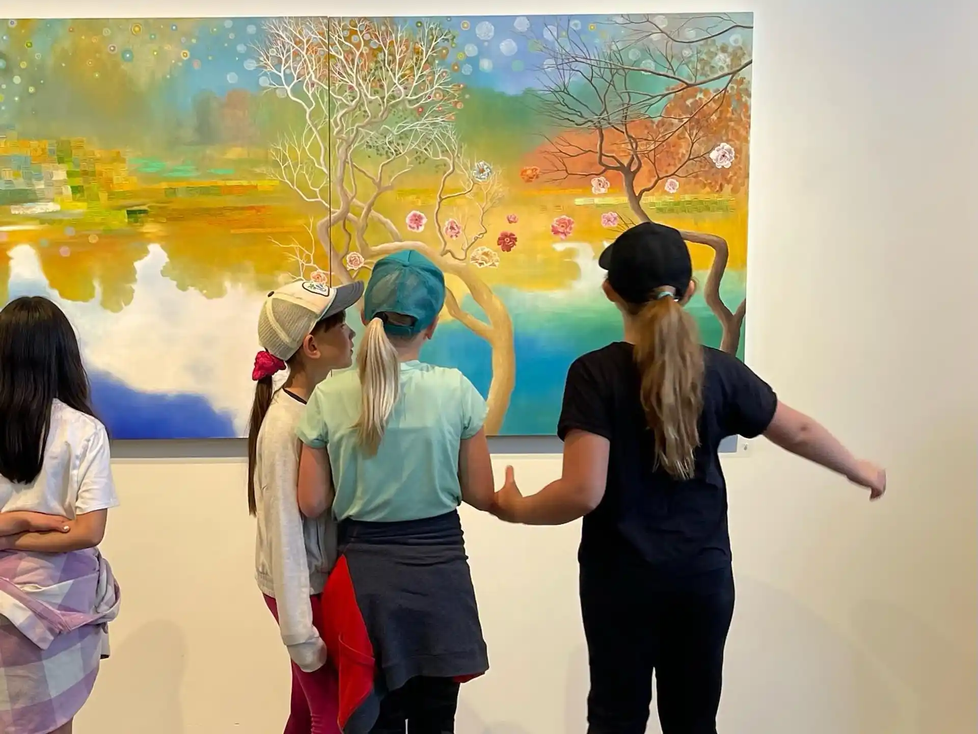 a group of people standing in front of a painting