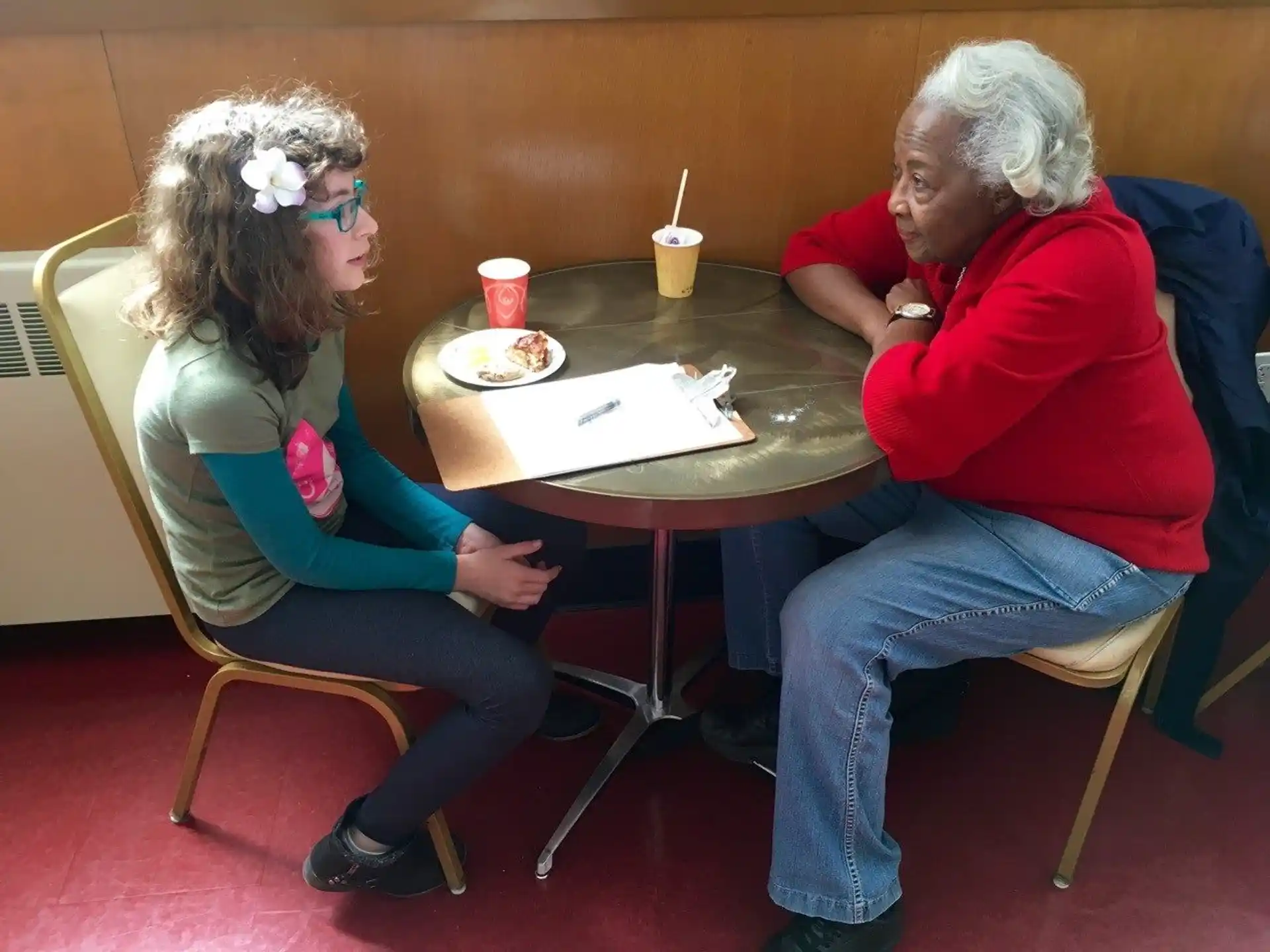 a woman and a girl sitting at a table with food